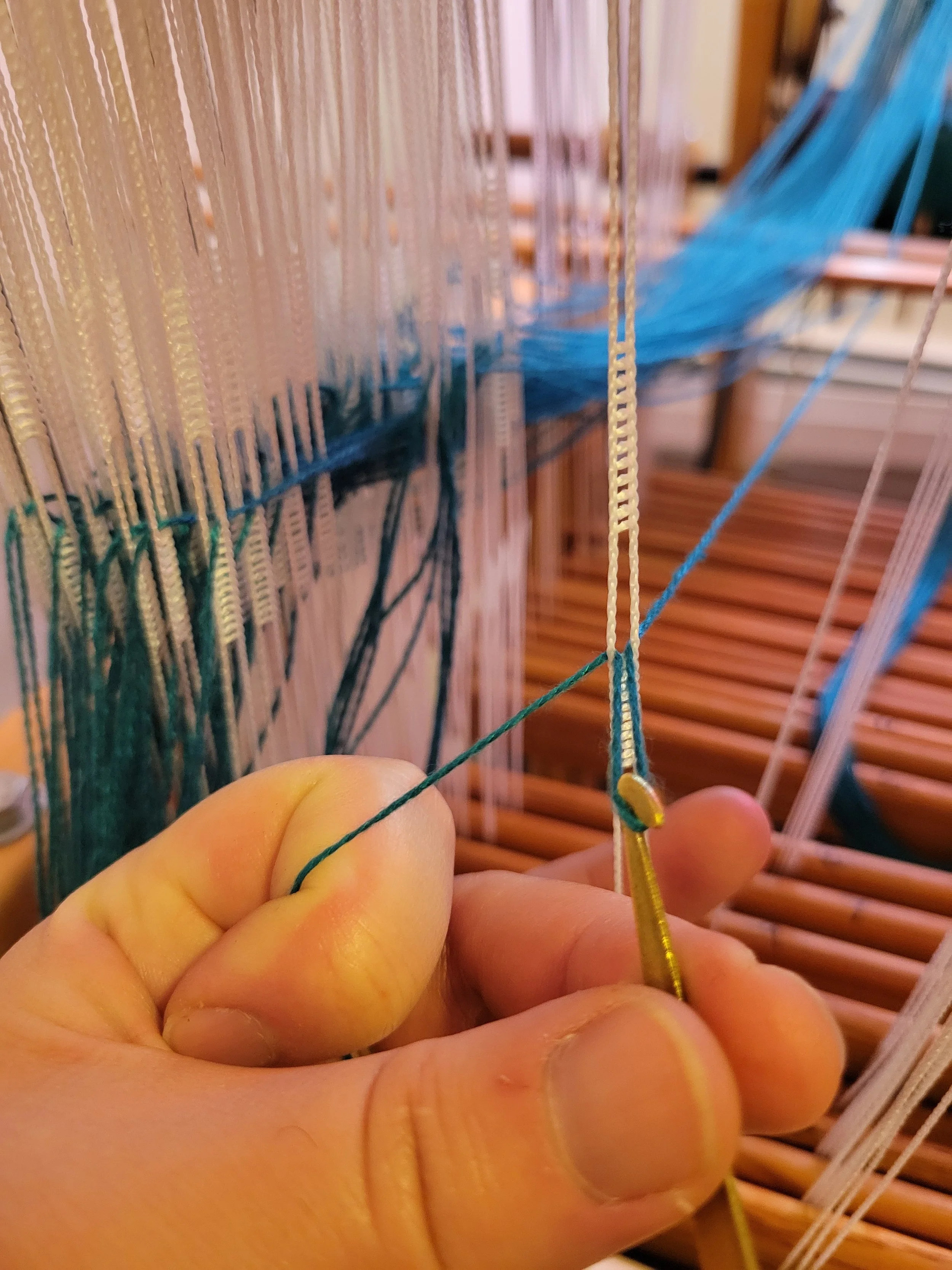 Each warp end is threaded through a device called a "heddle" on 1 of up to 24 harnesses that lift and lower independently of each other.