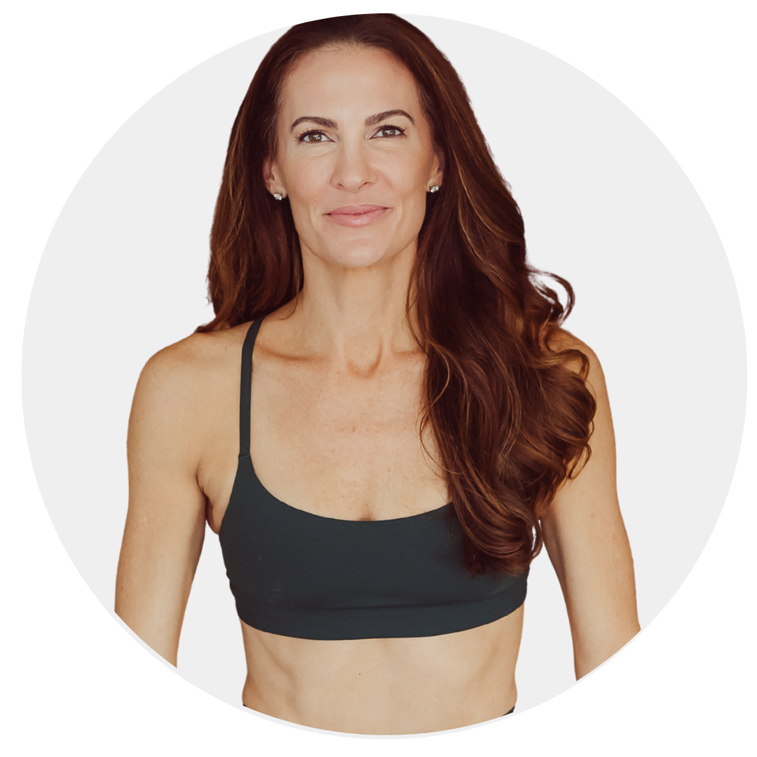 A close-up portrait of a smiling woman with blonde hair, wearing a white top and a delicate necklace, with a plain white background.