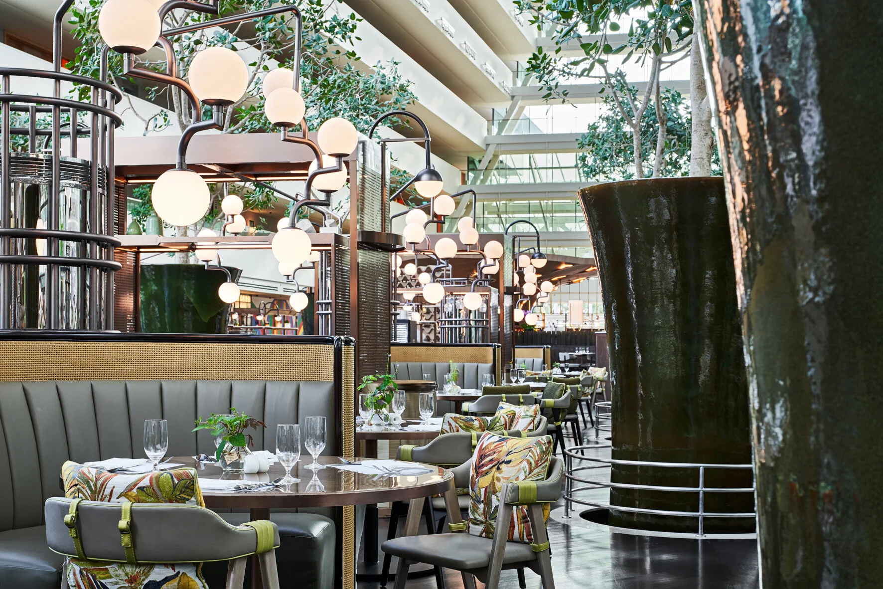 The curved banquettes with light “canopies” and the glazed clay vases
