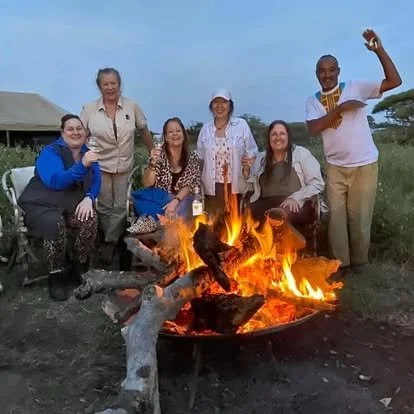 The Safari Sisters and expert guide Khalfan enjoying the campfire at one of the 'glamping style' tented lodges.