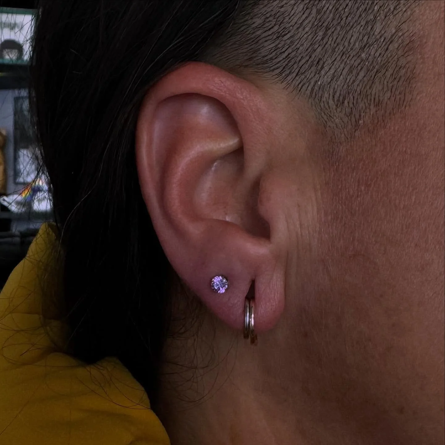 Lobe piercing by @emerald.cowgirl using a fancy purple cz from @neometaljewelry 💜✨ we&rsquo;re loving the pop of color next to the mixed metal rings we installed a couple years ago!

We have a piercer on staff Tuesday through Saturday, noon-6pm! &bu