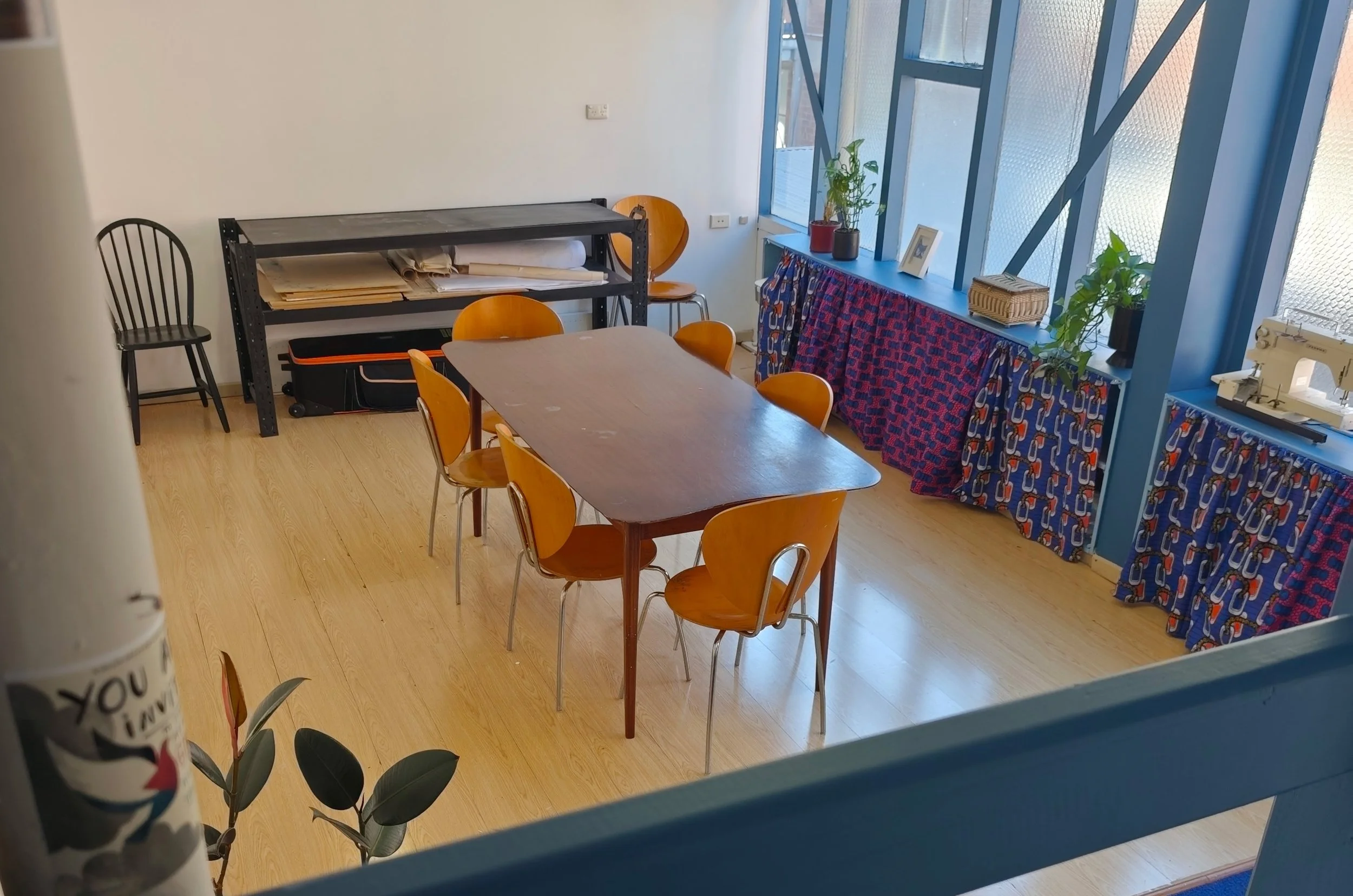 Art studio room, light filled, colourful shelving and a table
