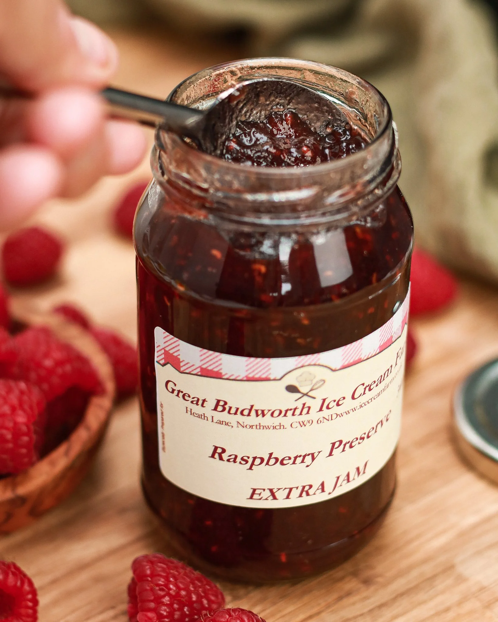 spooning raspberry jam out of jar