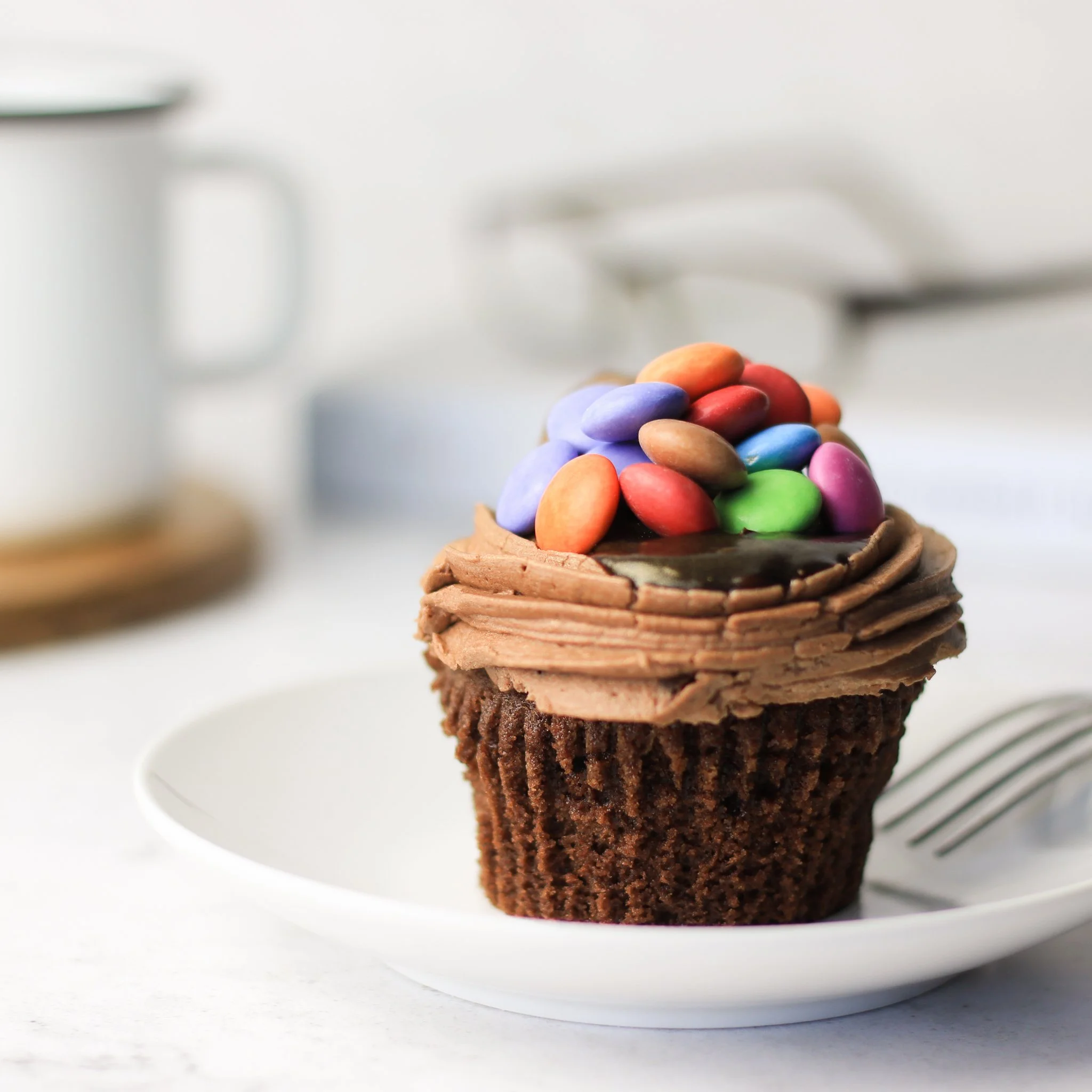 chocolate cupcake with icing and smarties