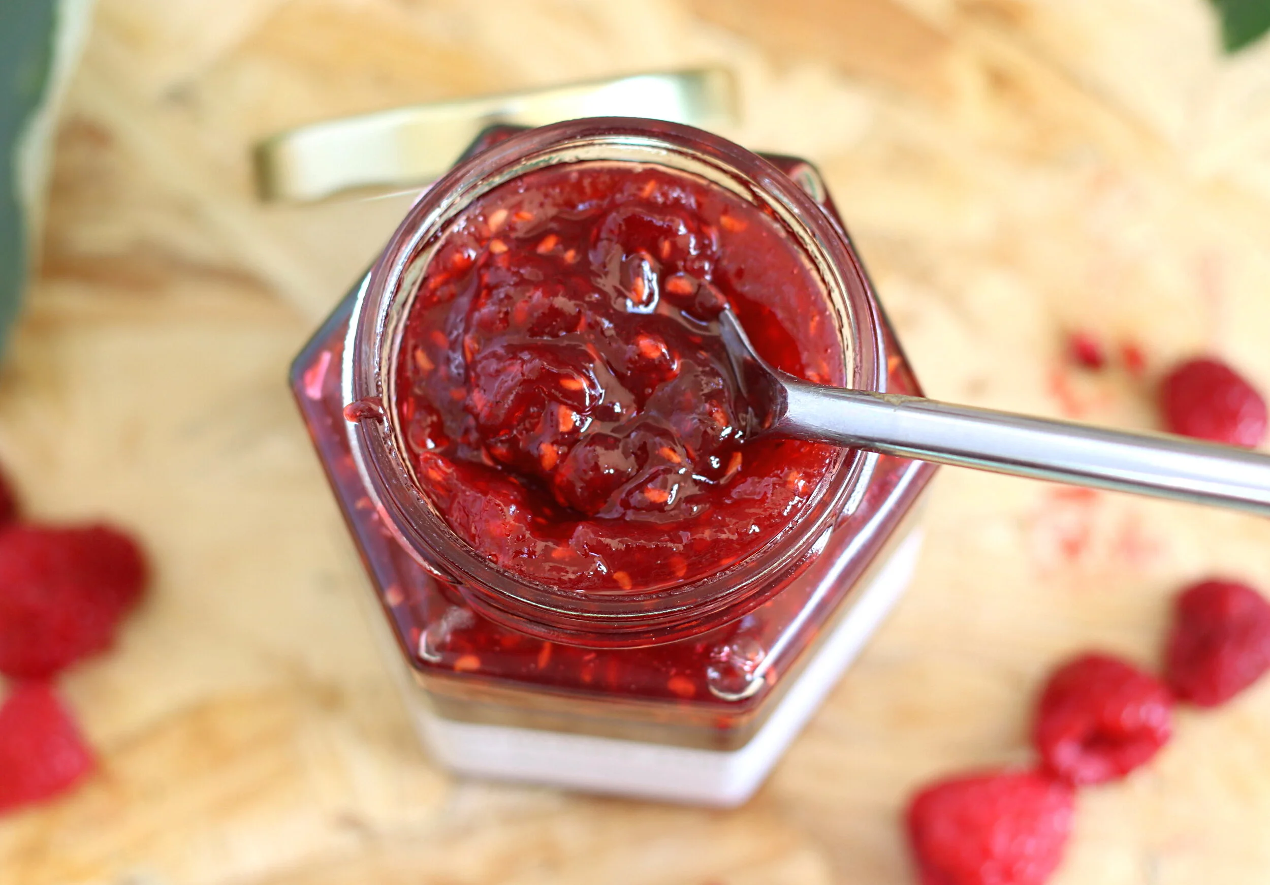 view of raspberry jam jar from the top and raspberries