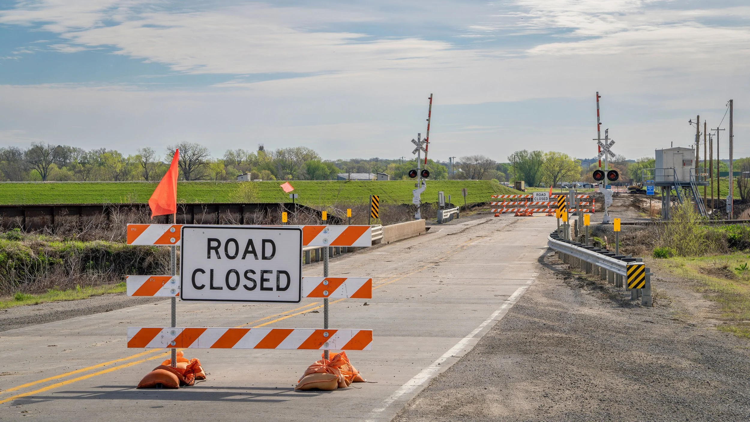 a road closed sign sits on the side of a road under construction