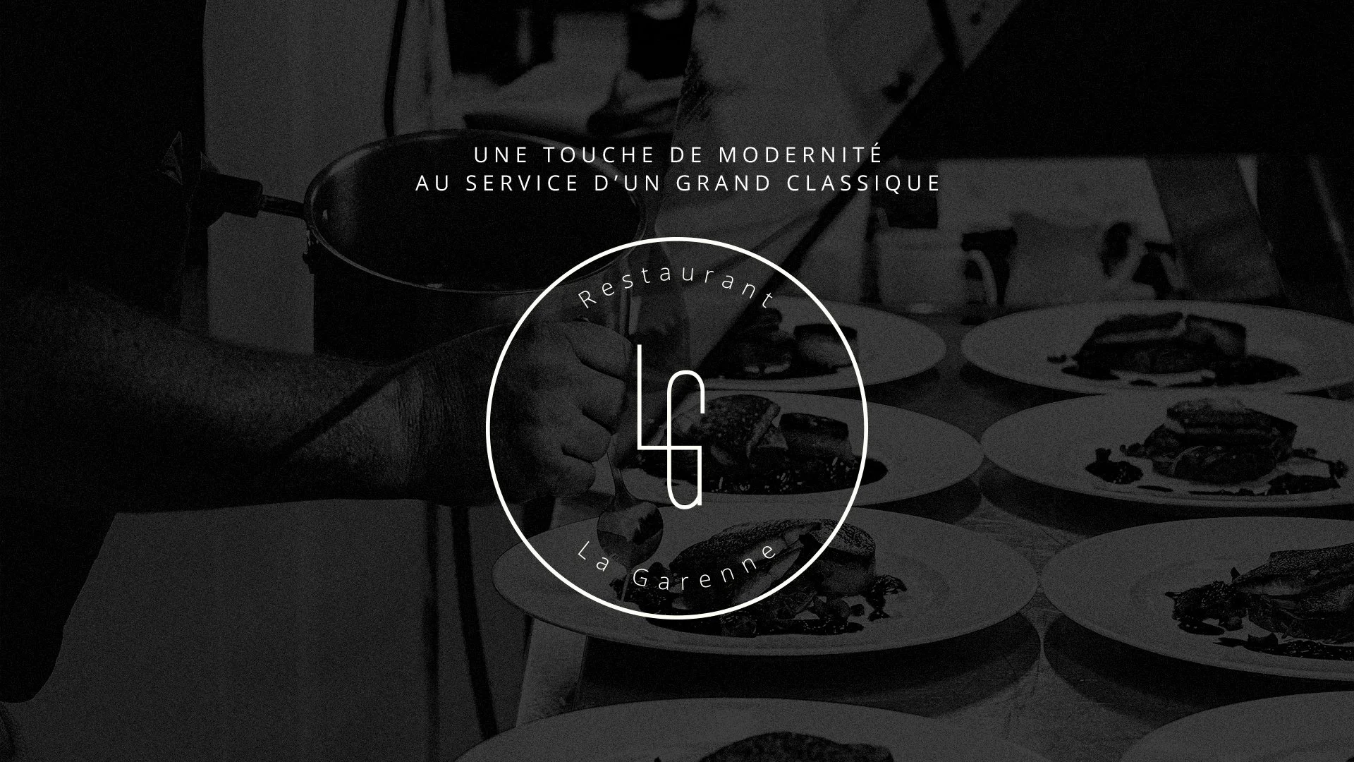 Une photo en noir et blanc d'une cuisine ou d'un restaurant, avec plusieurs plats appétissants et une main qui sert une sauce ou un condiment sur un plat, symbolisant une cuisine moderne au service d'un grand classique.