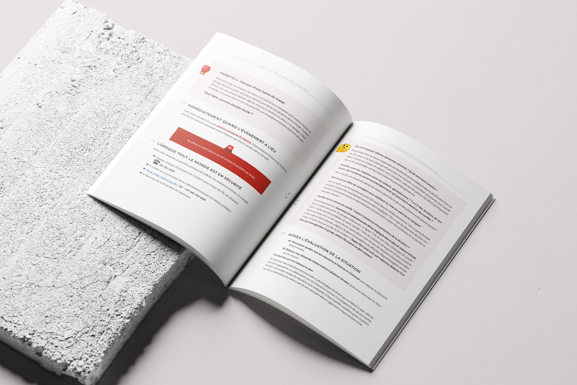 Un livre ouvert posé sur une surface blanche, avec une structure en béton à côté.