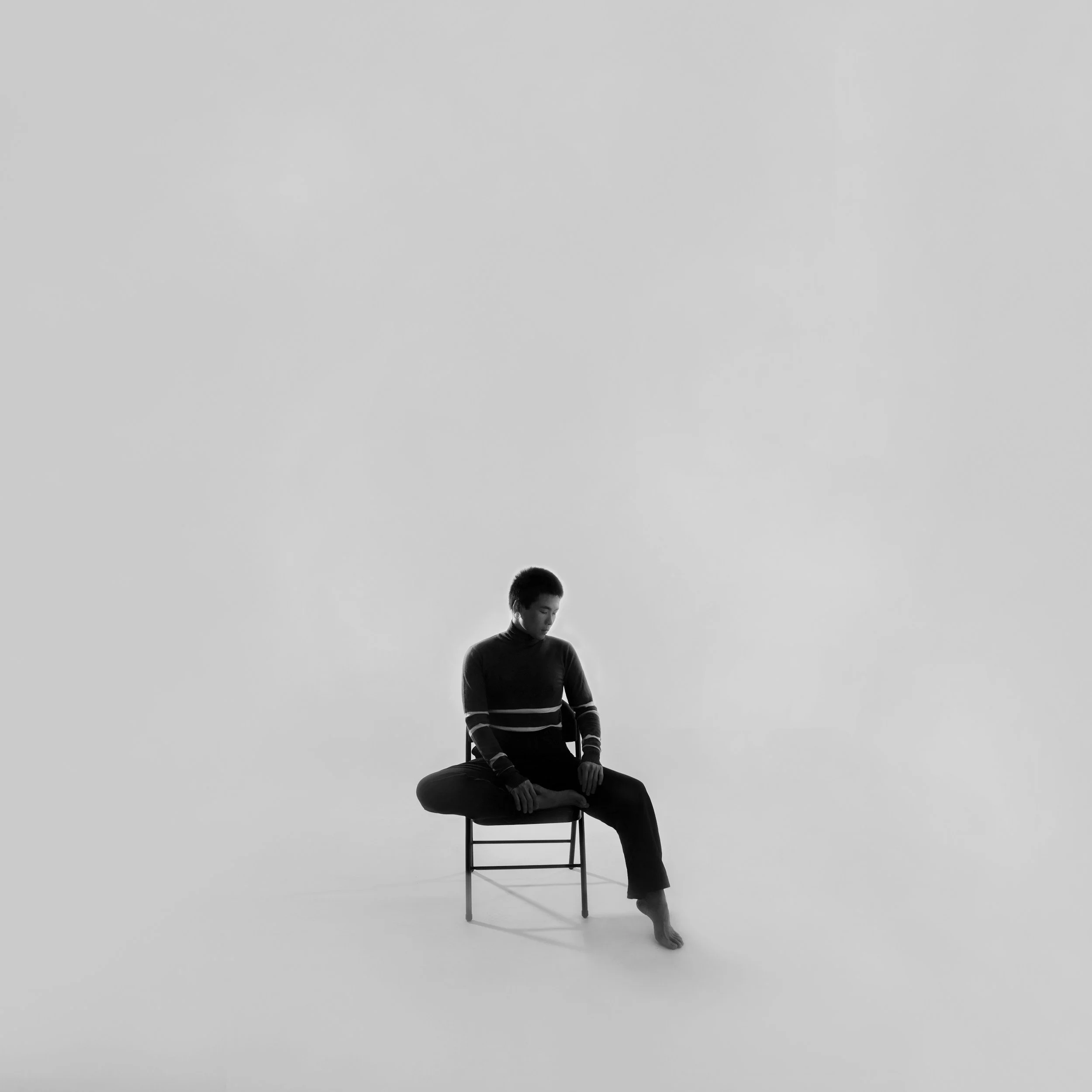 A founder sitting on a chair alone in a white room