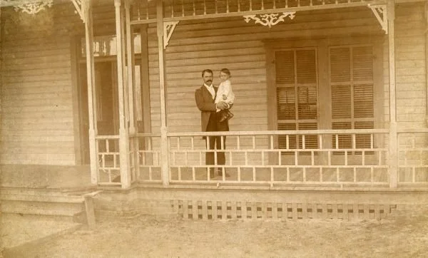 William Sherman Jennings holding 18-month-old son on porch of his home