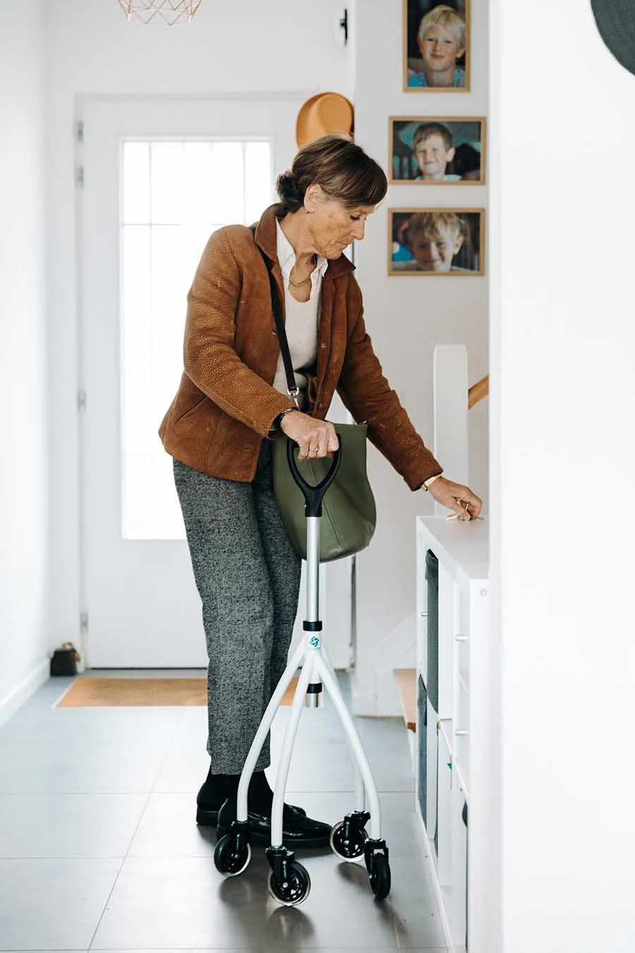 Senior woman with walking device at home doing laundry