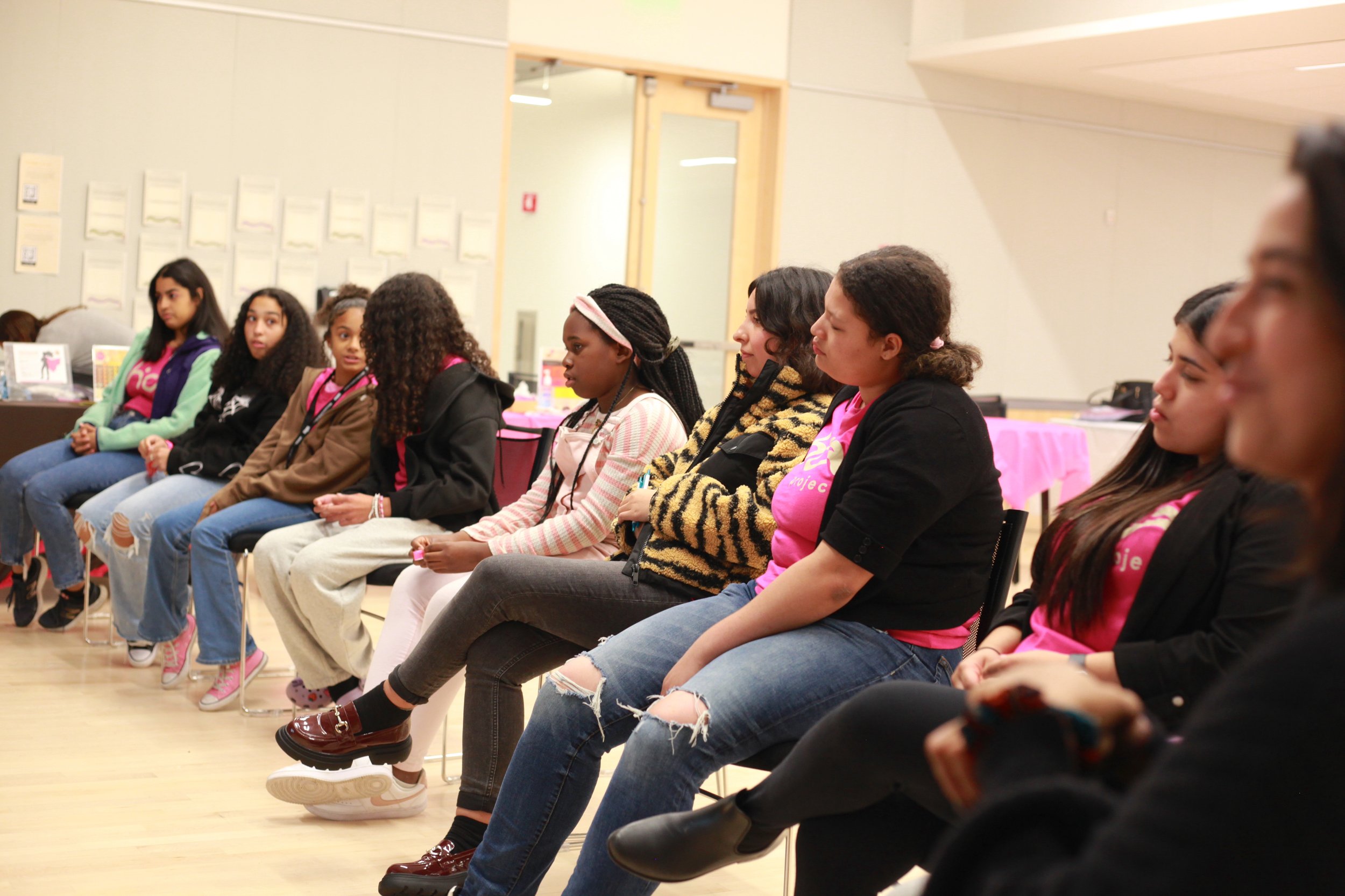 A group of Black and Latina girls seated together at a Chicas Connect program session in Boston, building community connections and professional development through Chica Project's alumni network