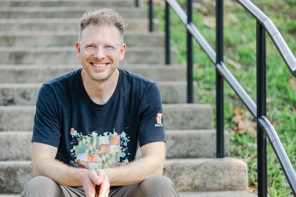Seth Holmes seated outdoors wearing a Holmes Watercolors shirt