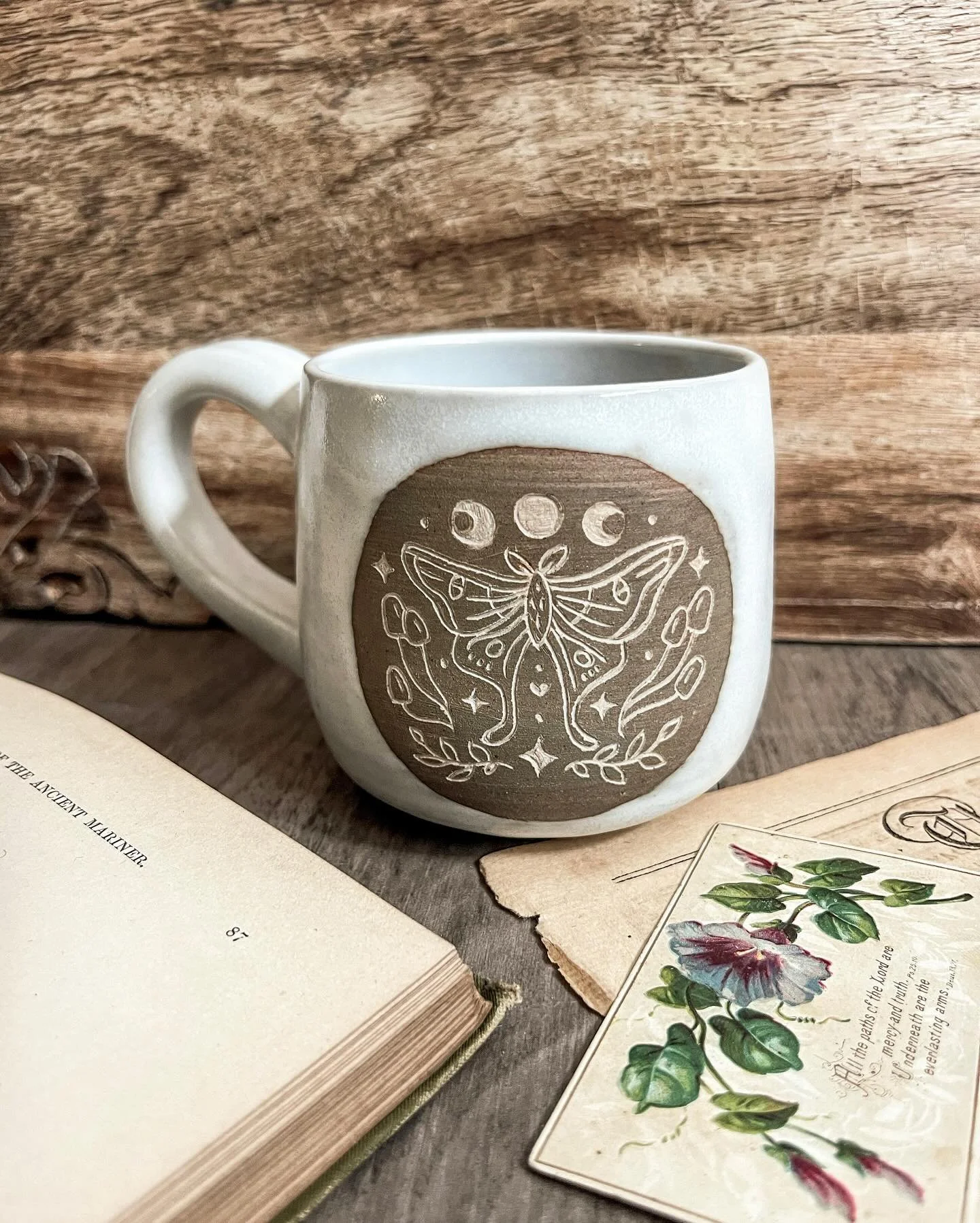 As we’re working on moving my (rather large) handmade mug collection to our new home, I felt like it would be a good time to reshare one of my favorites I’ve made! This is a handcarved moth mug, created with olive slip. I definitely would