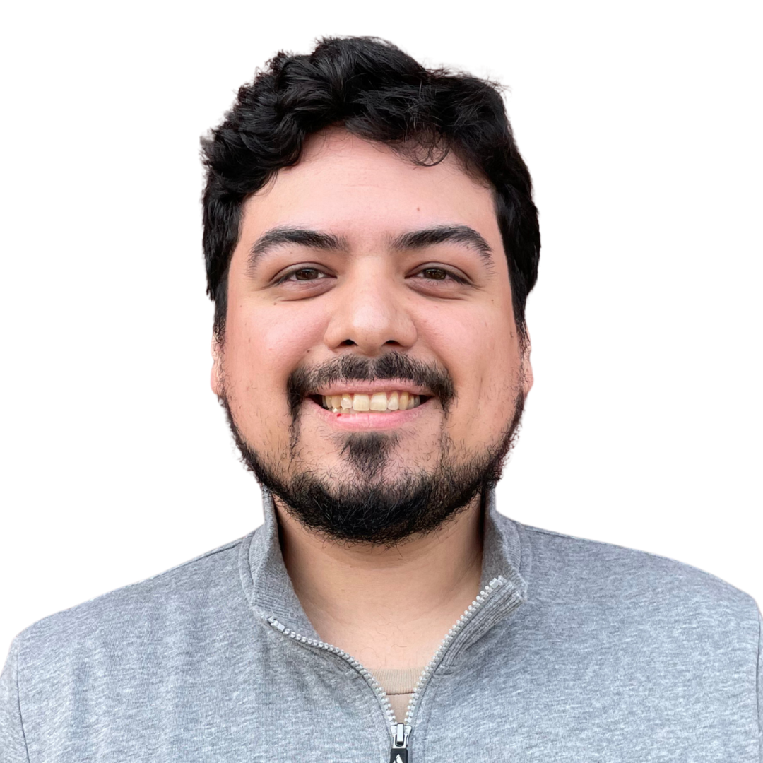 Portrait of a smiling man with dark hair and a beard, wearing a gray zip-up sweater.