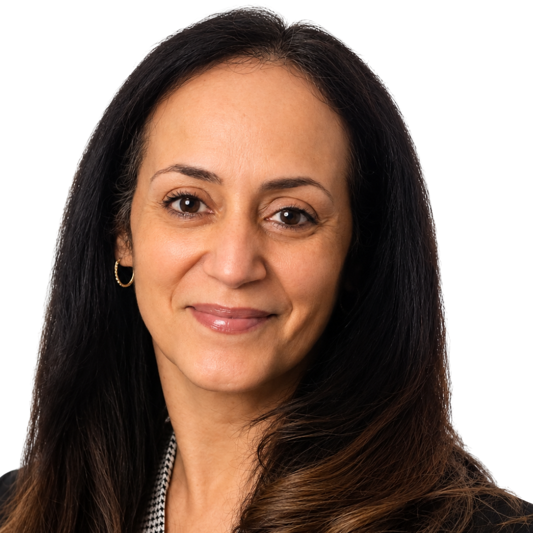 A woman with long dark hair, light skin, and gold hoop earrings, smiling slightly against a plain white background.