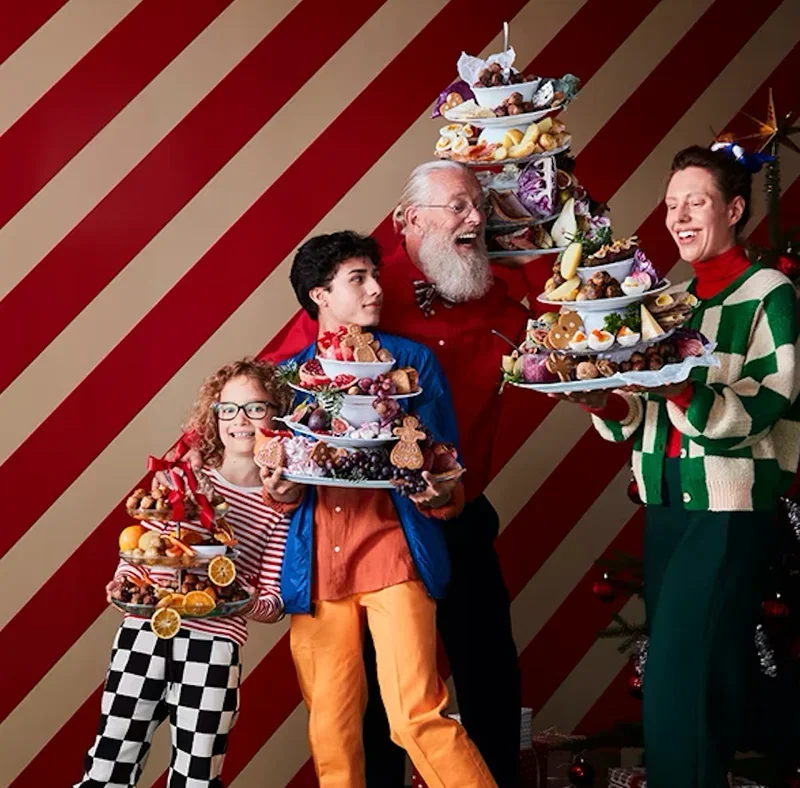 a-number-of-people-holding-stacks-of-dishes-loaded-with-swedish-treats-from-ikea.png.webp