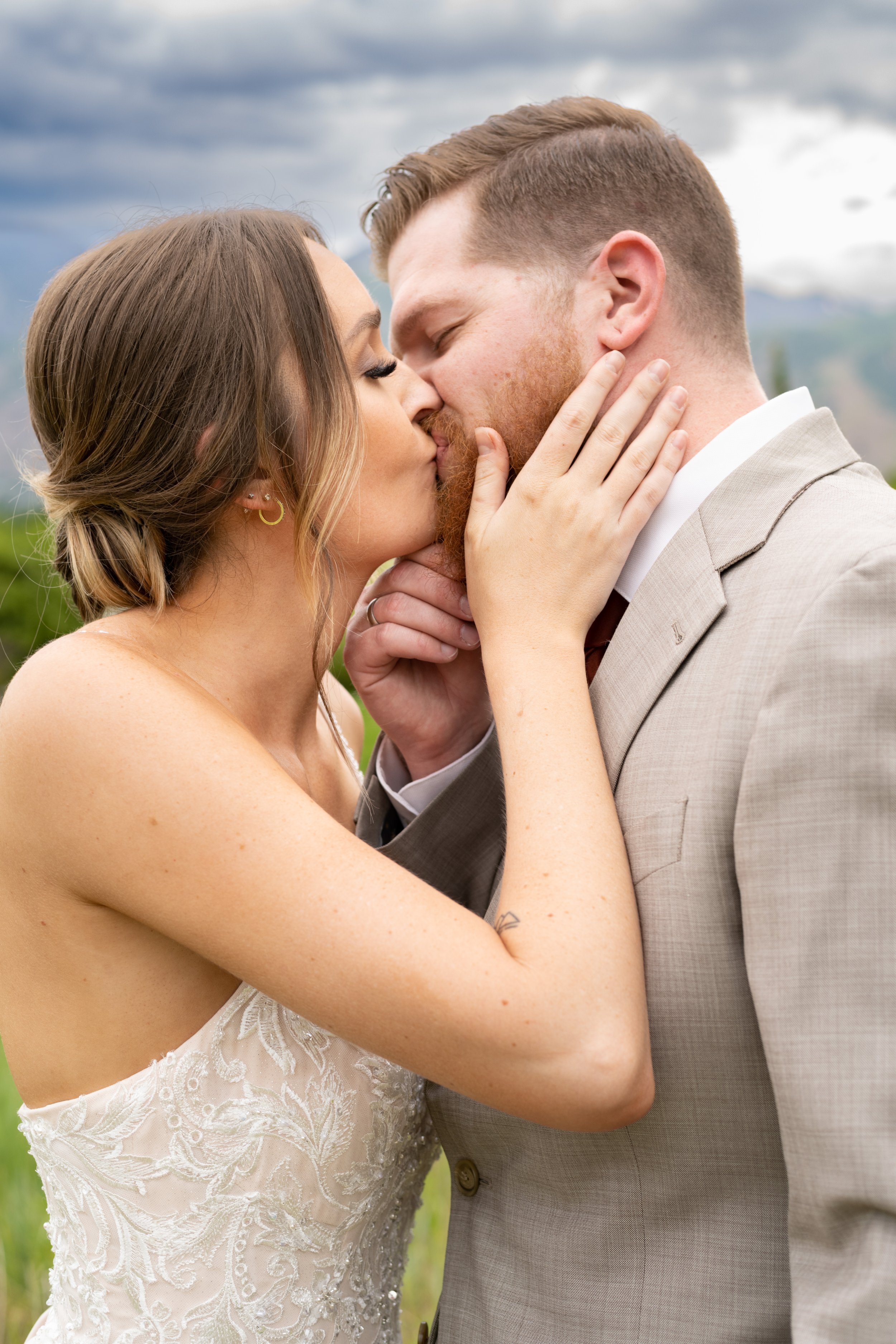 A close up of a couple kissing in wedding attire
