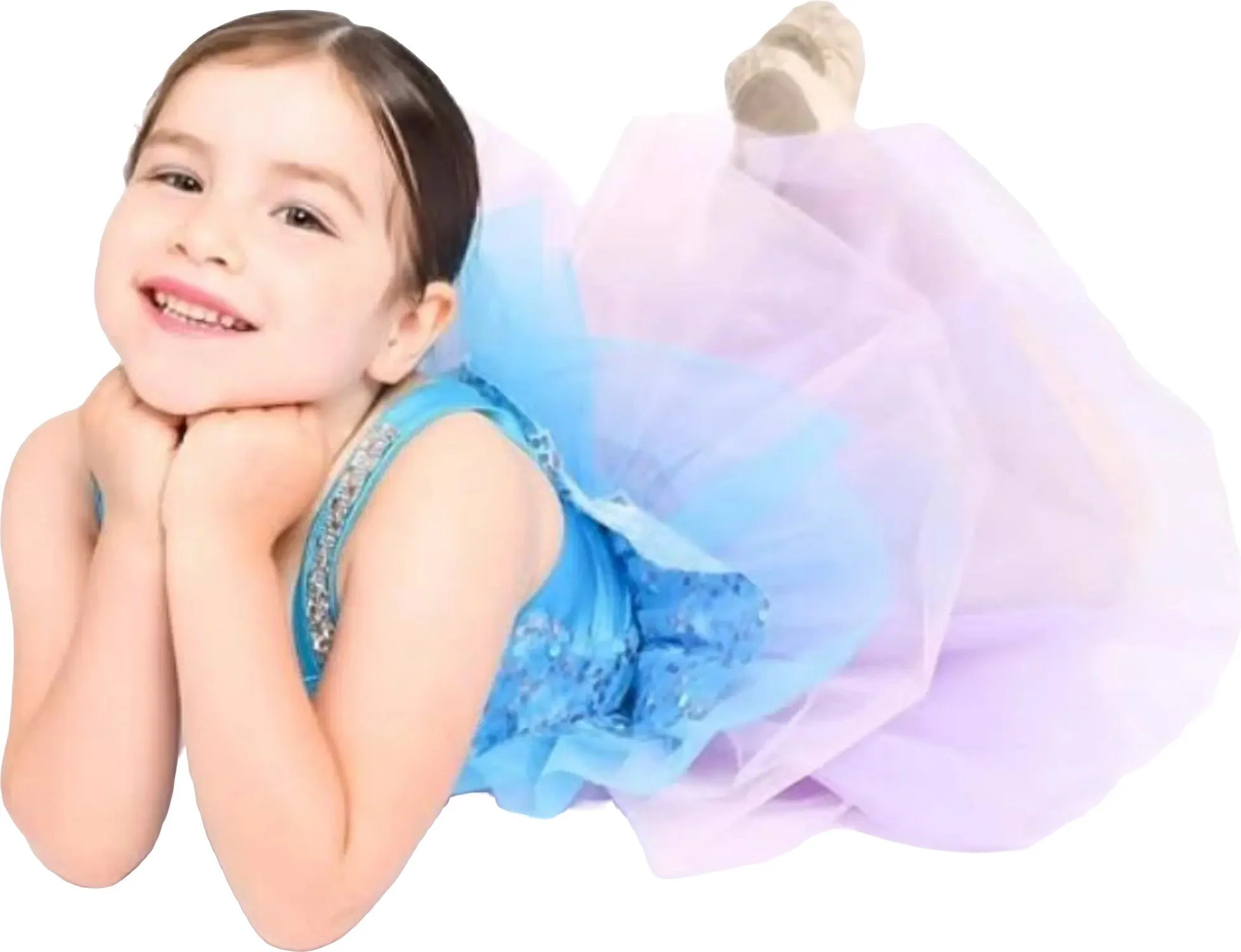 A young girl in a blue dress with a fluffy tutu posing with her chin resting on her hands and smiling at the camera.