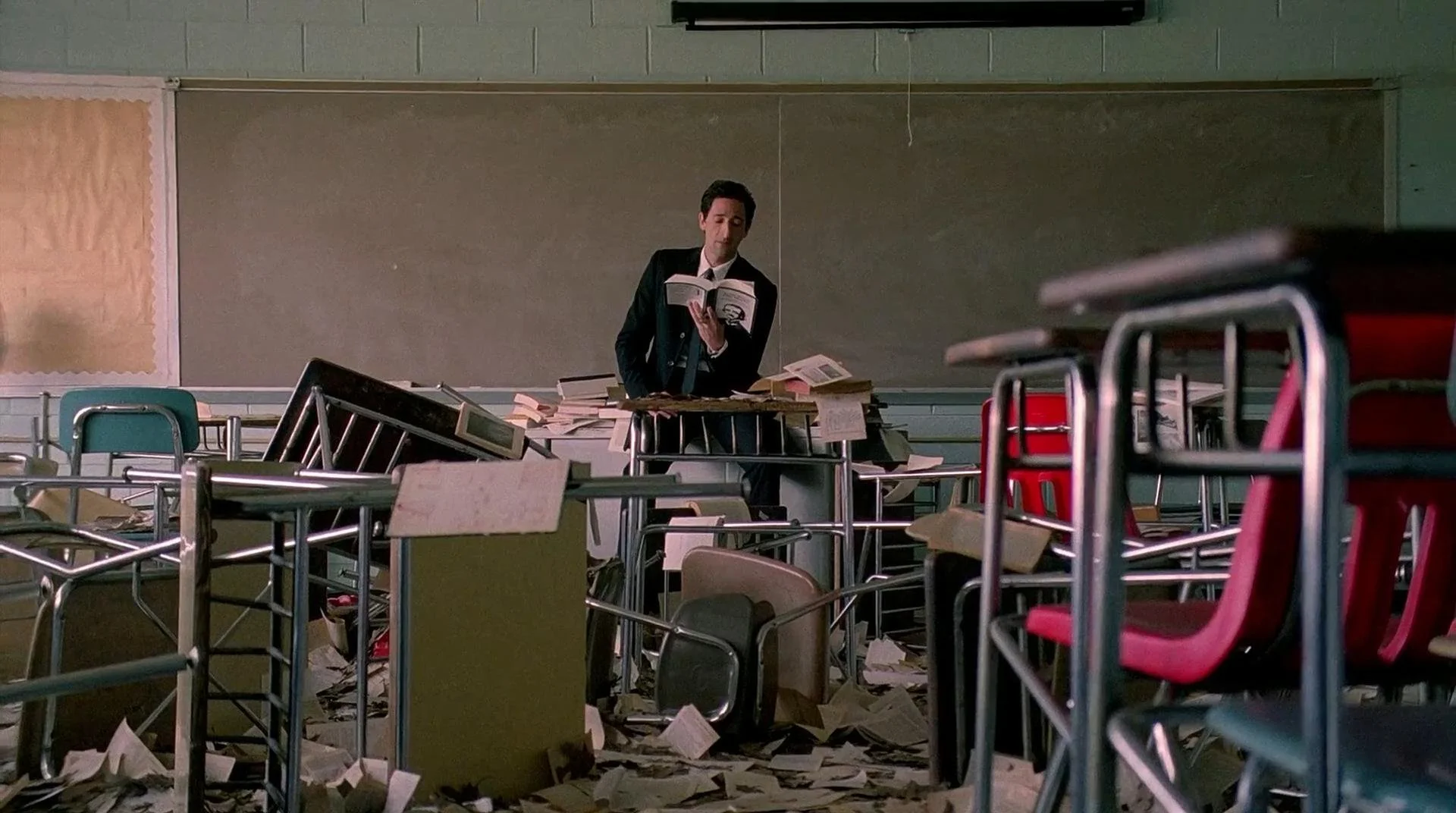 Henry (Adrien Brody) sits in a classroom.