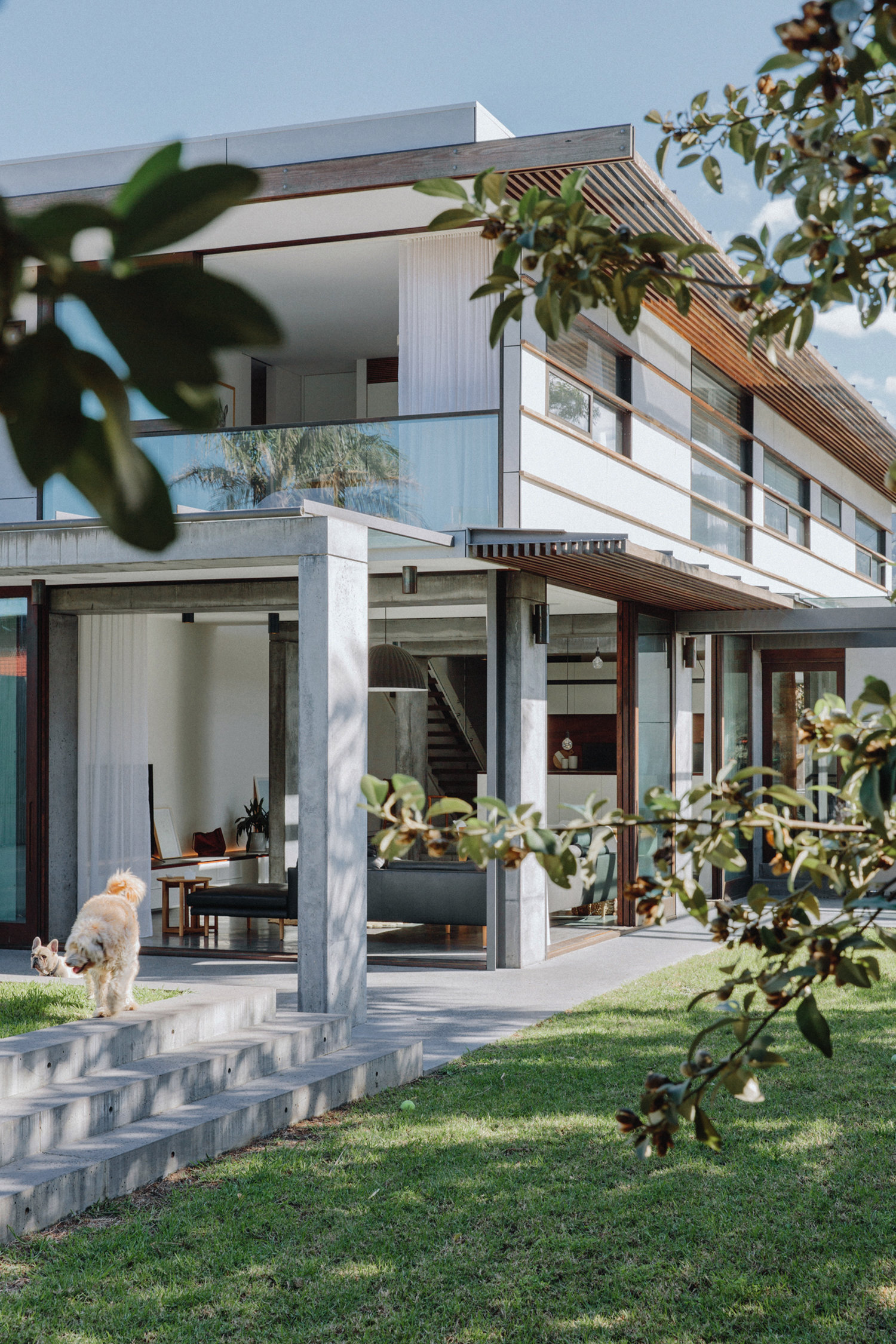 External view of double storey home featuring multi panel sliding glass doors, awning windows and fixed glazing.