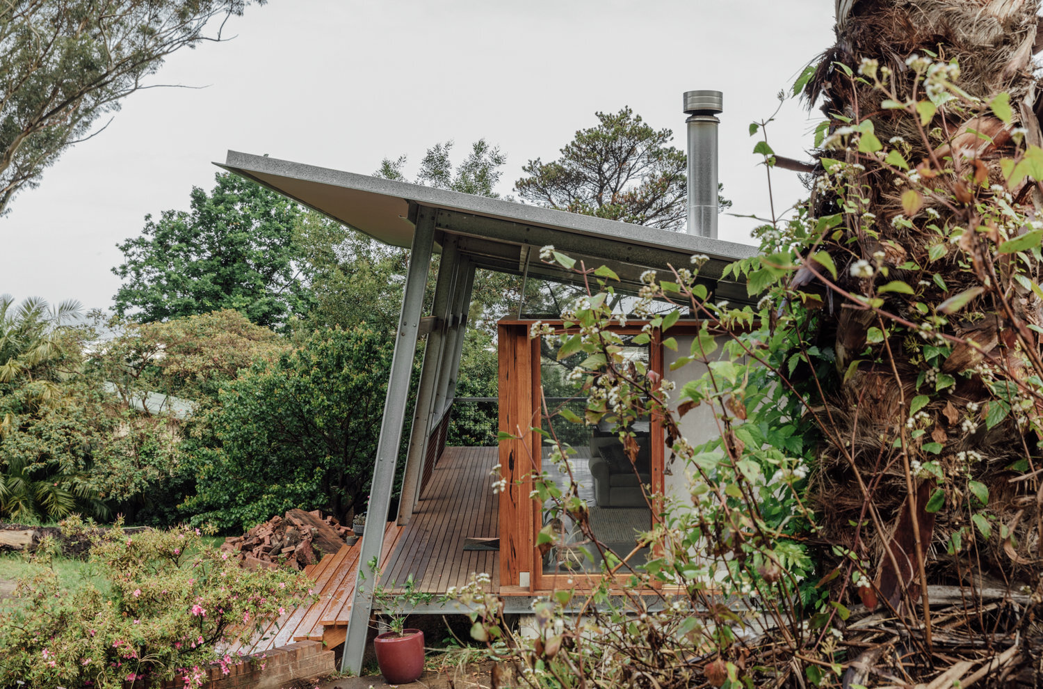 Exterior view of fixed glazed window-walls and slide over wall glazing door made from recycled Australian hardwood.