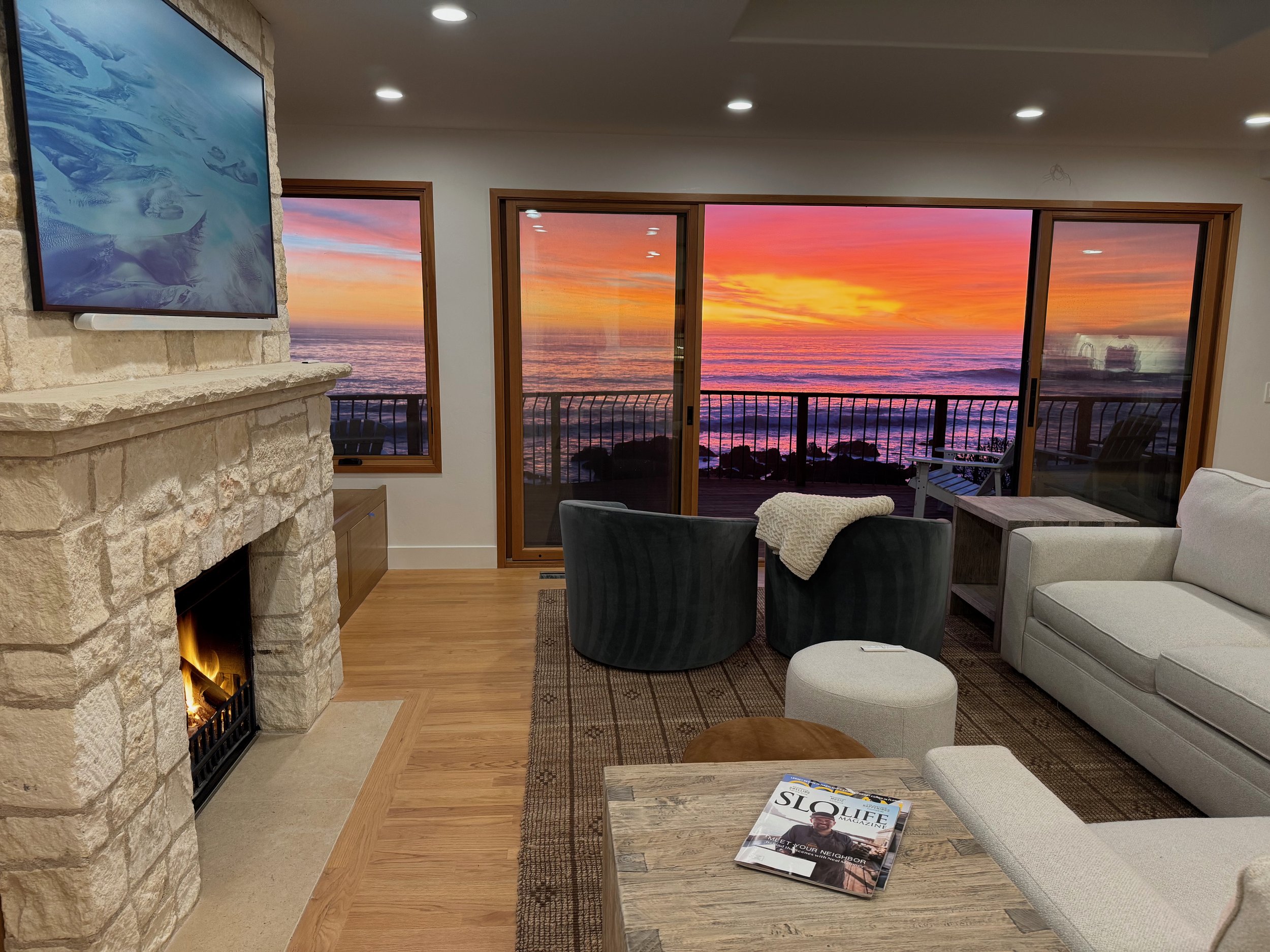Gorgeous sunsets abound in this view from the newly remodeled living room with 65" smart Frame TV, remote controlled gas fireplace, and comfy couch, chairs, and corner bench seat overlooking the sea.
