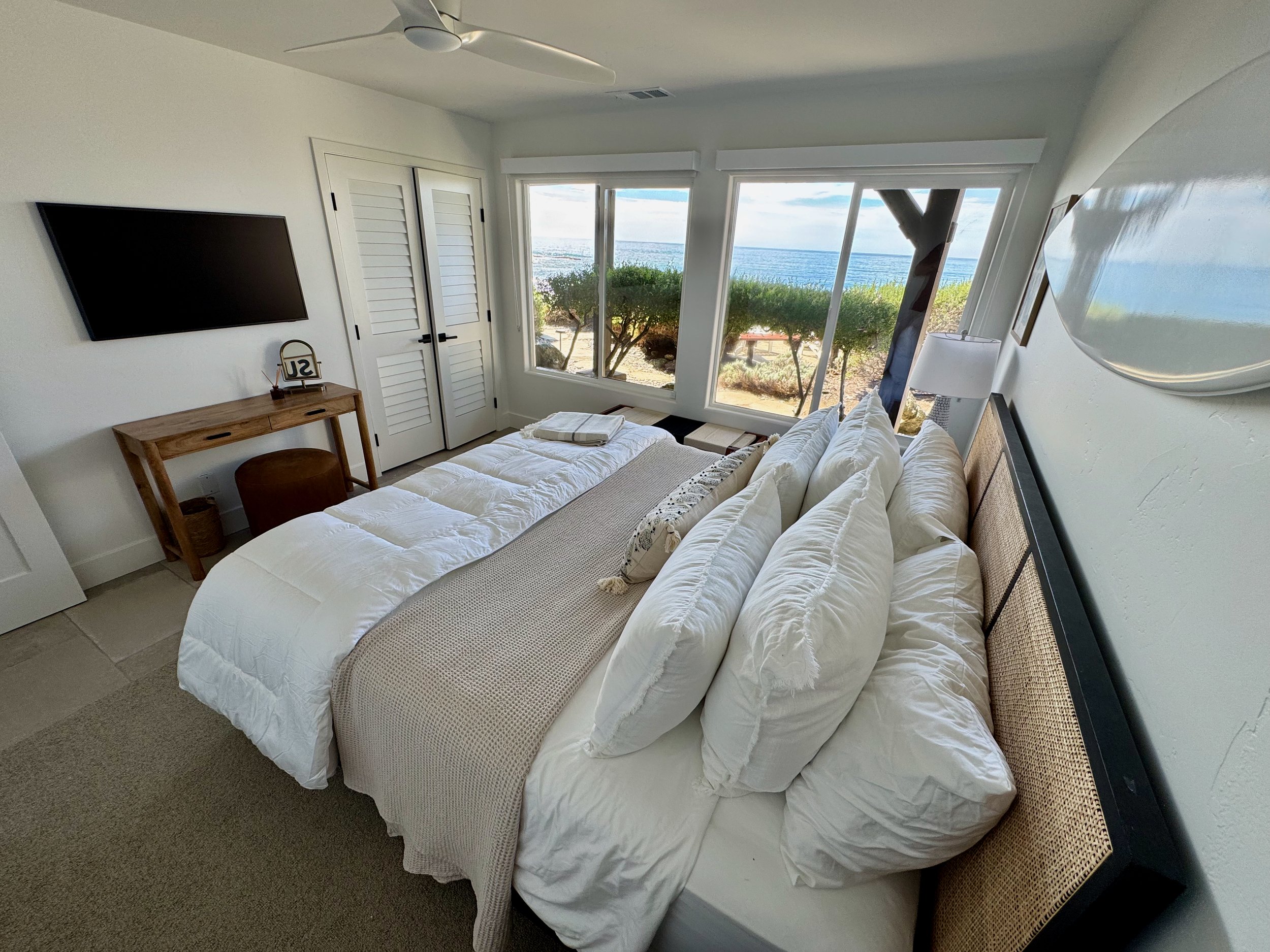 "Surf" bedroom, smaller downstairs guest room with king bed & Frame TV.