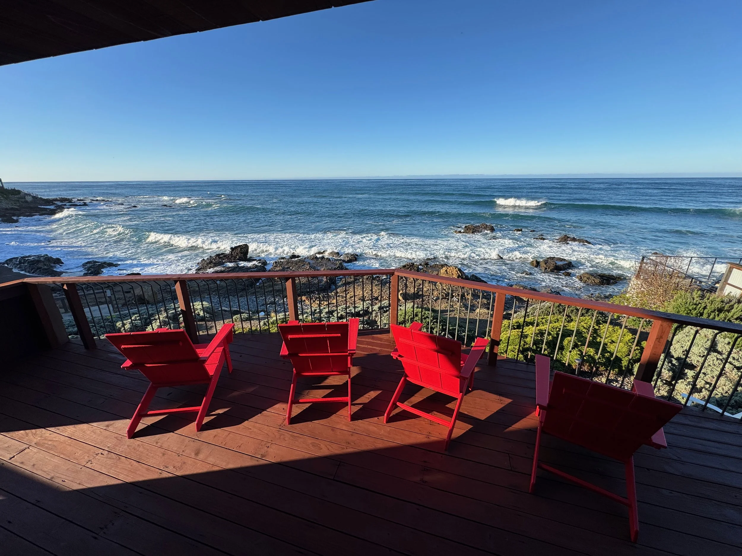 Morning deck with red chairs at Oceanfront Cambria.jpeg
