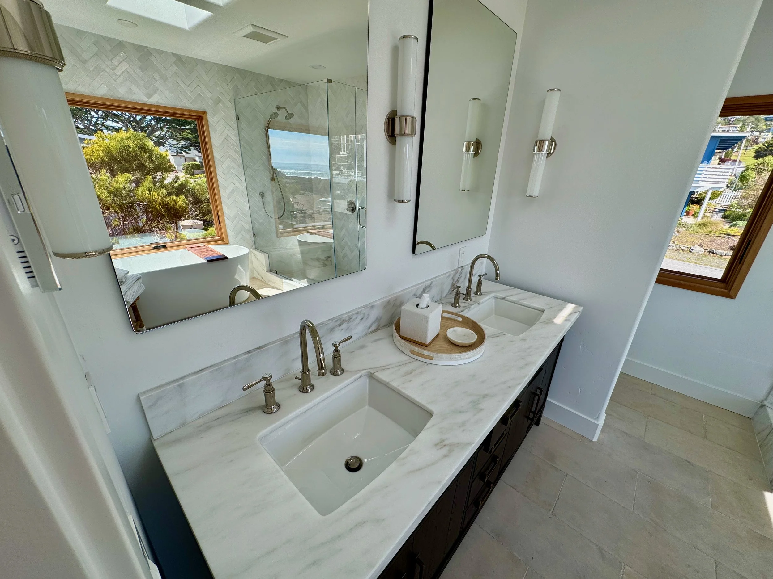 New master bathroom with custom marble countertops, soaking tube, shower, and world class ocean view.