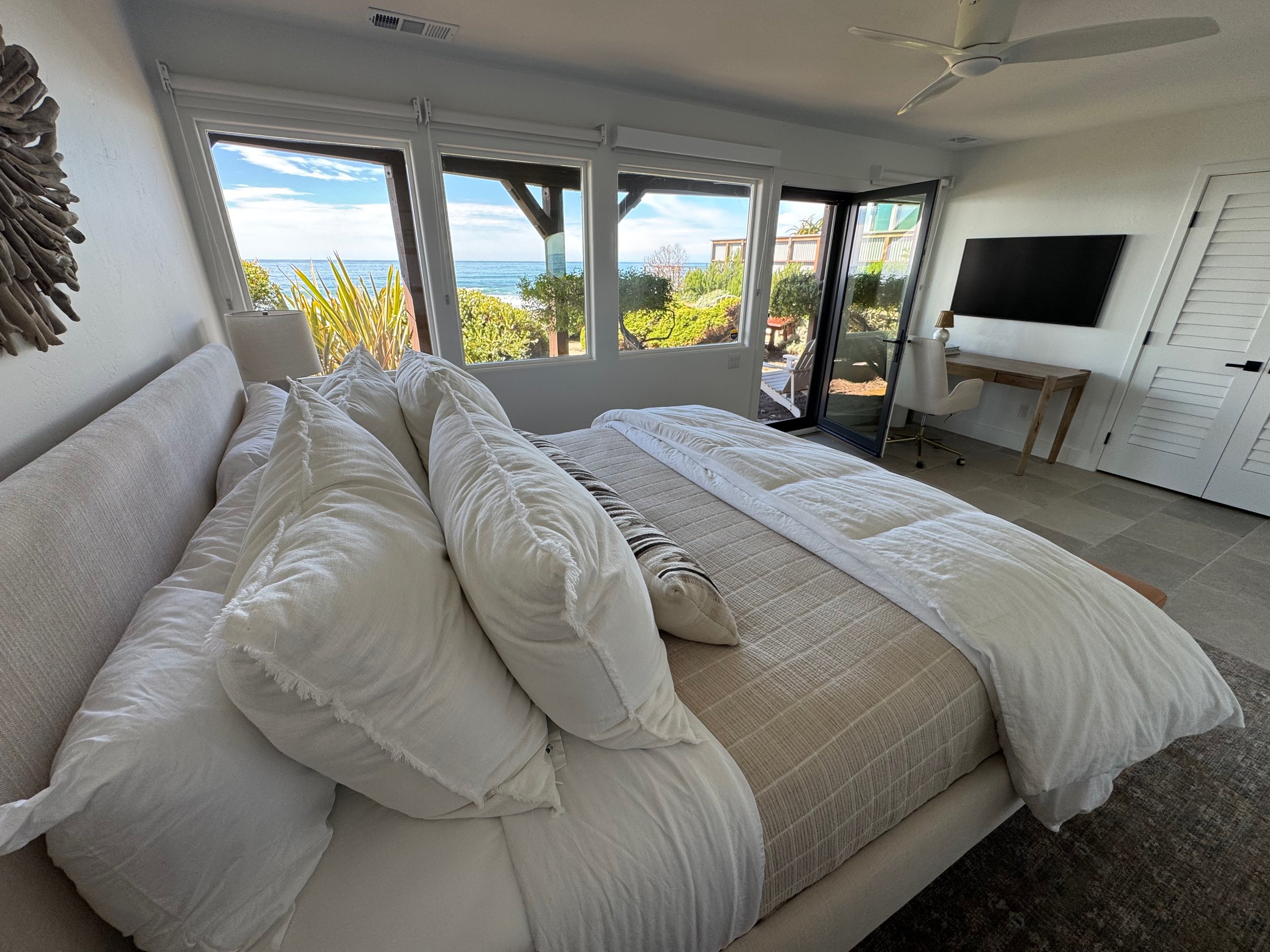 Downstairs larger bedroom with king bed, desk,  and 4k Frame TV with direct access to back yard and fire pit.
