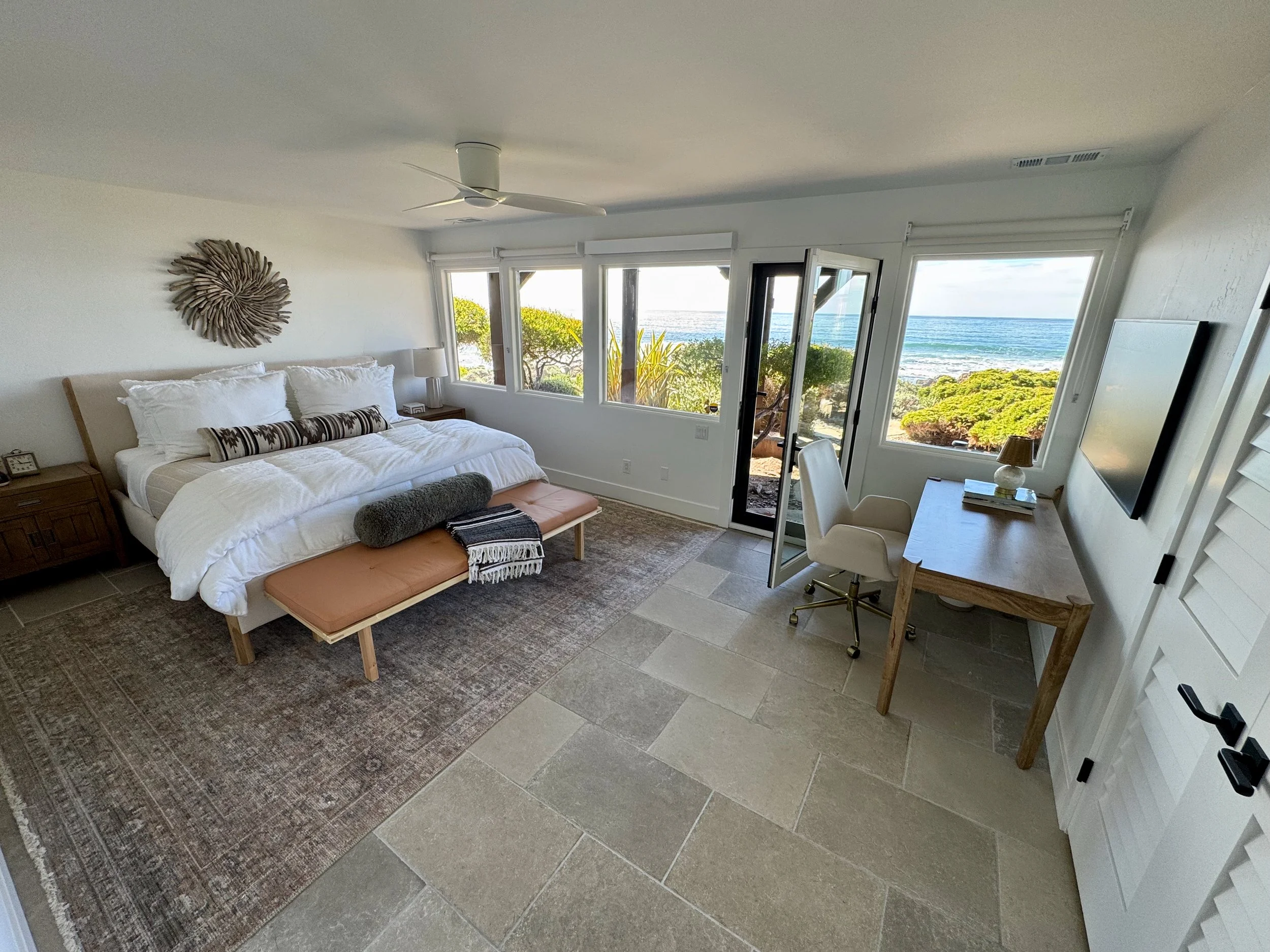 Downstairs larger guest bedroom with king bed and 4k Frame TV with direct access to ocean view back yard and fire pit.