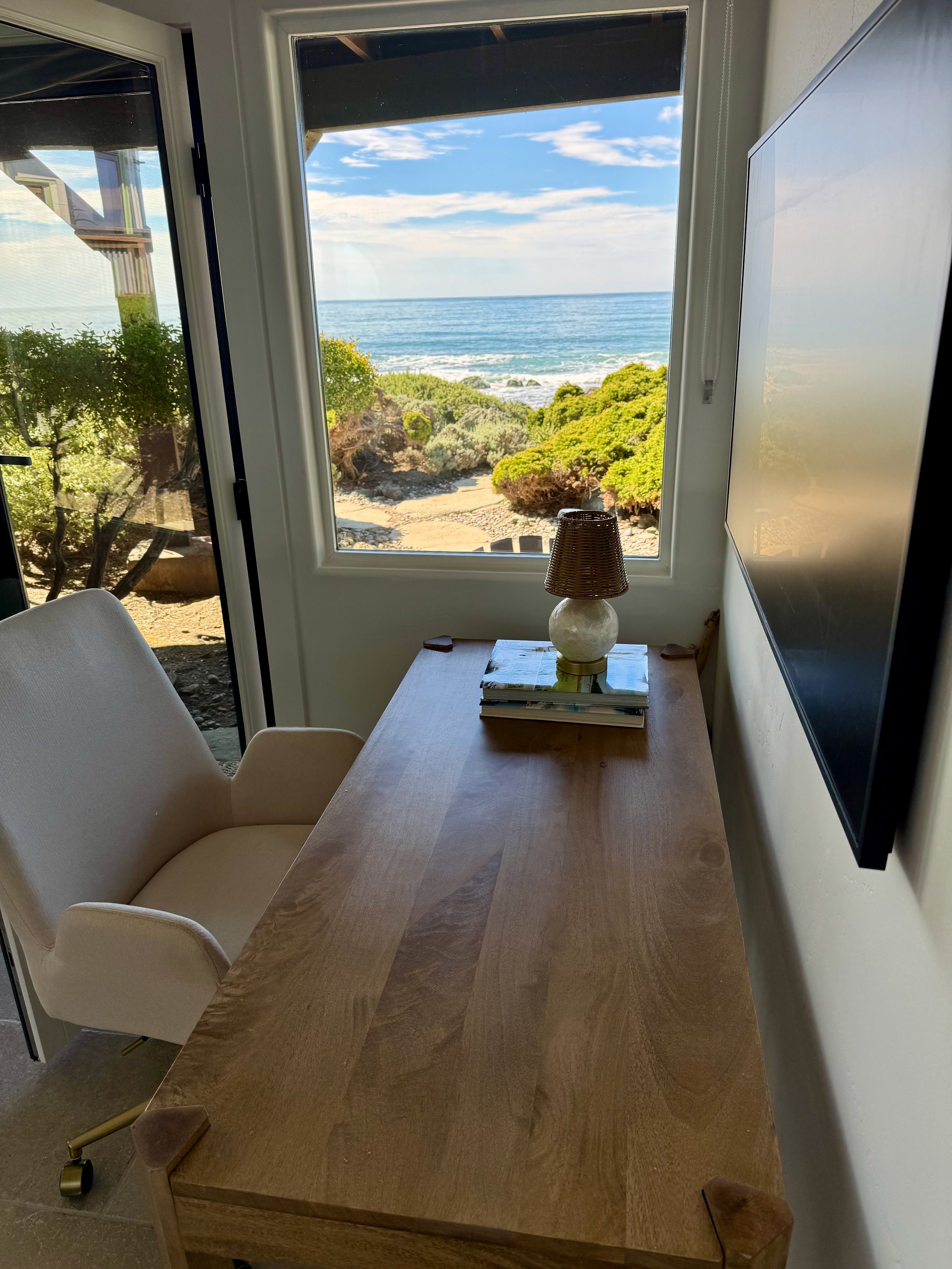 Downstairs larger guest bedroom desk with ocean view and door to back yard.