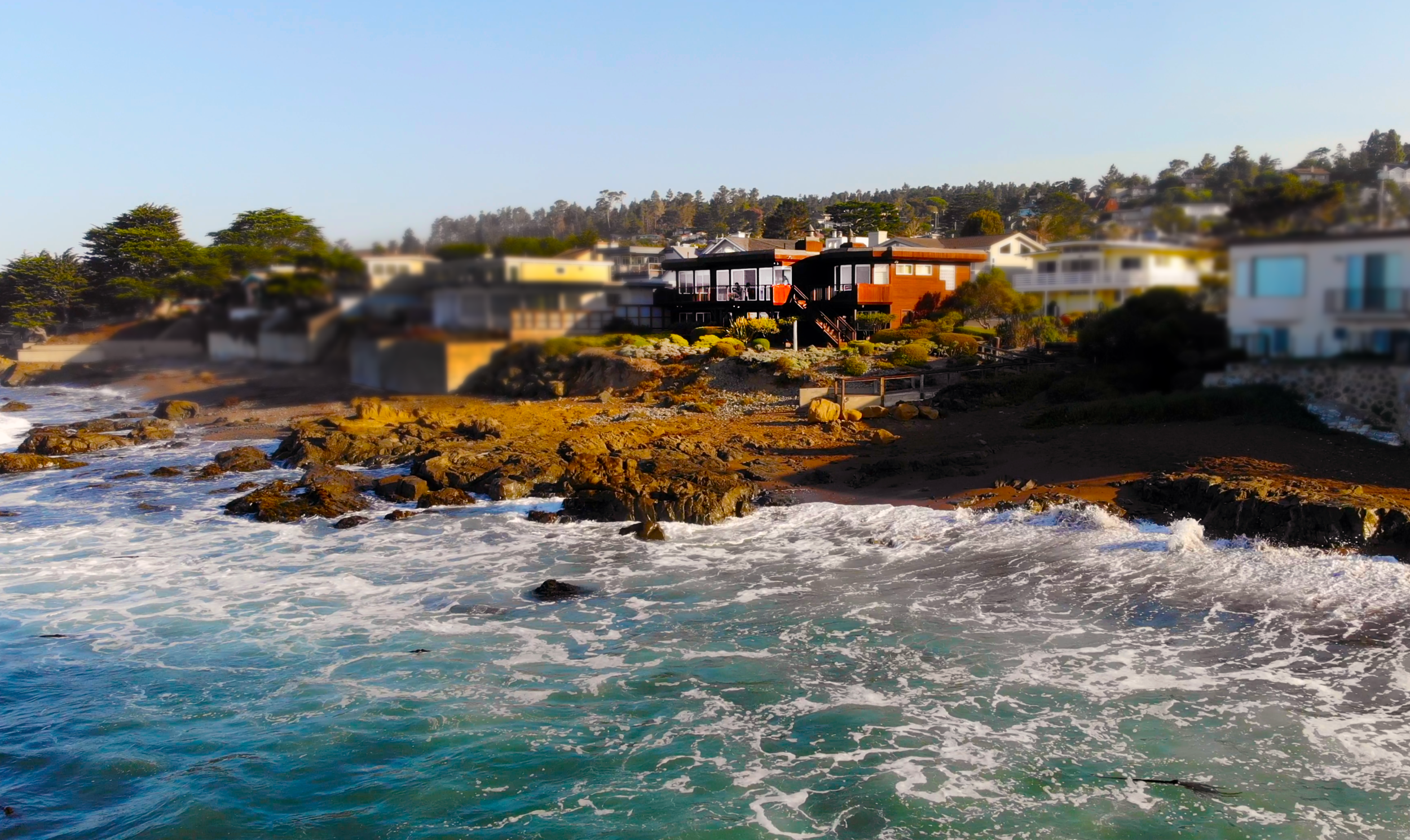 Oceanfront Cambria aerial still from sea with blur.png