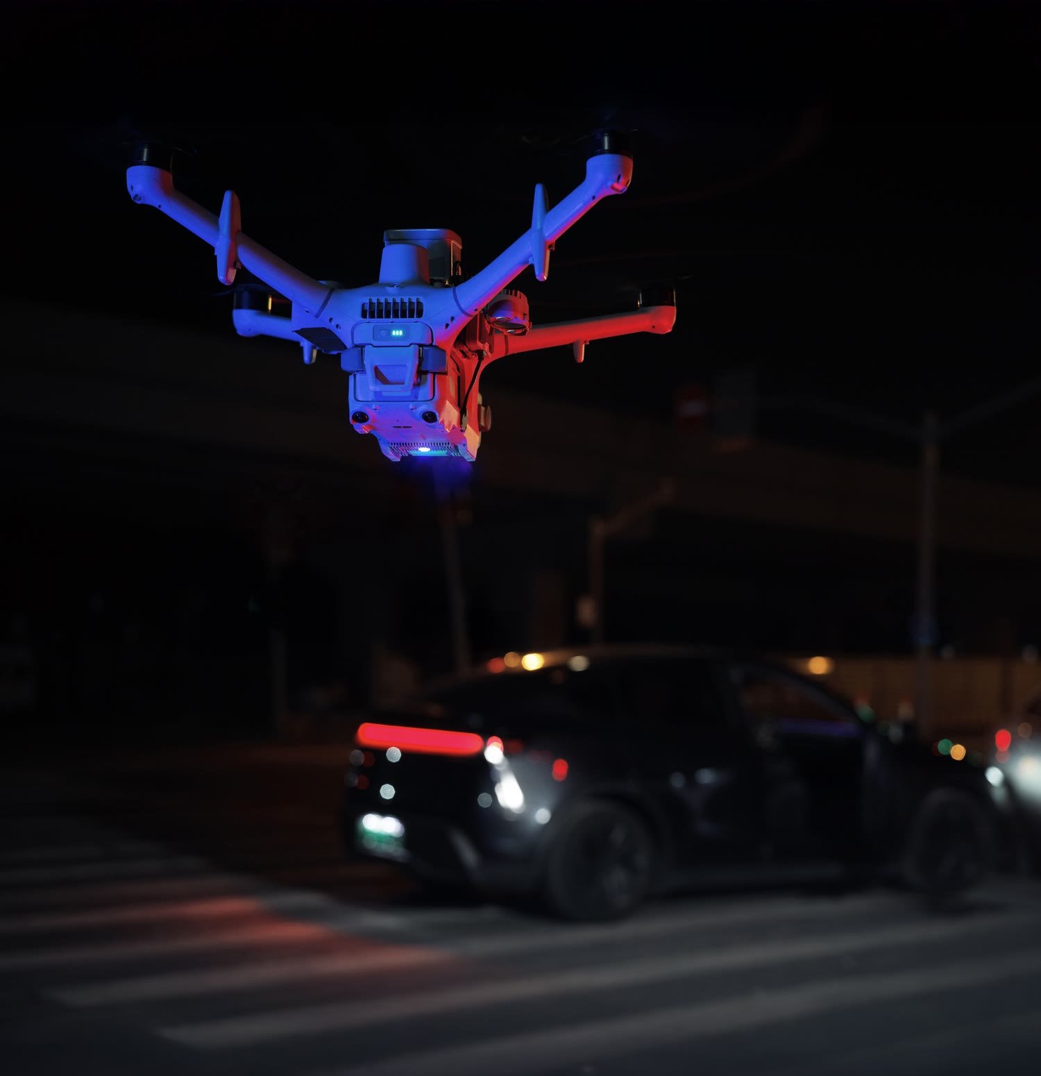 Matrice 5TD flashing red and blue warning lights above night-time traffic