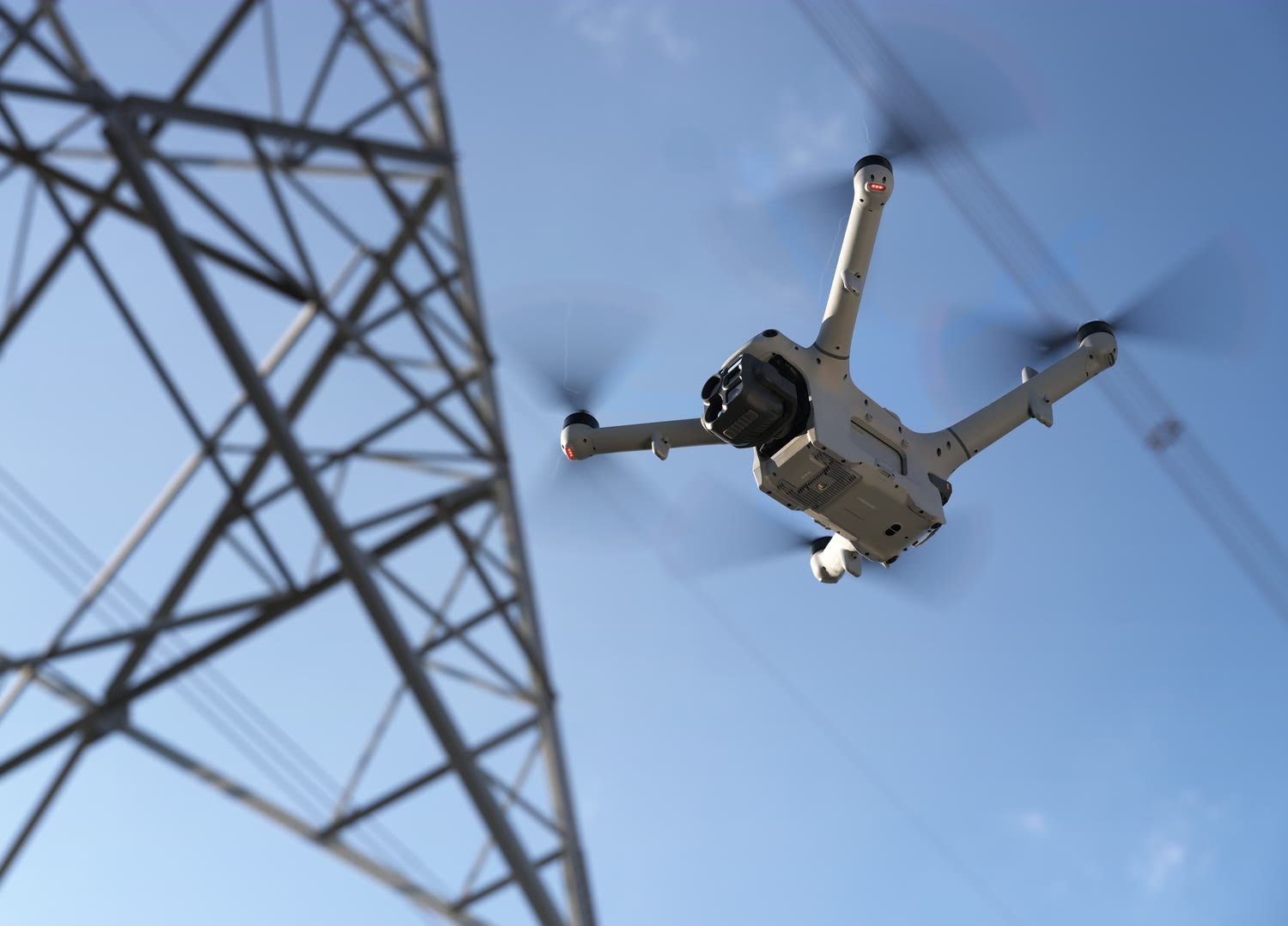 Matrice 5TD seen from below beside a transmission tower