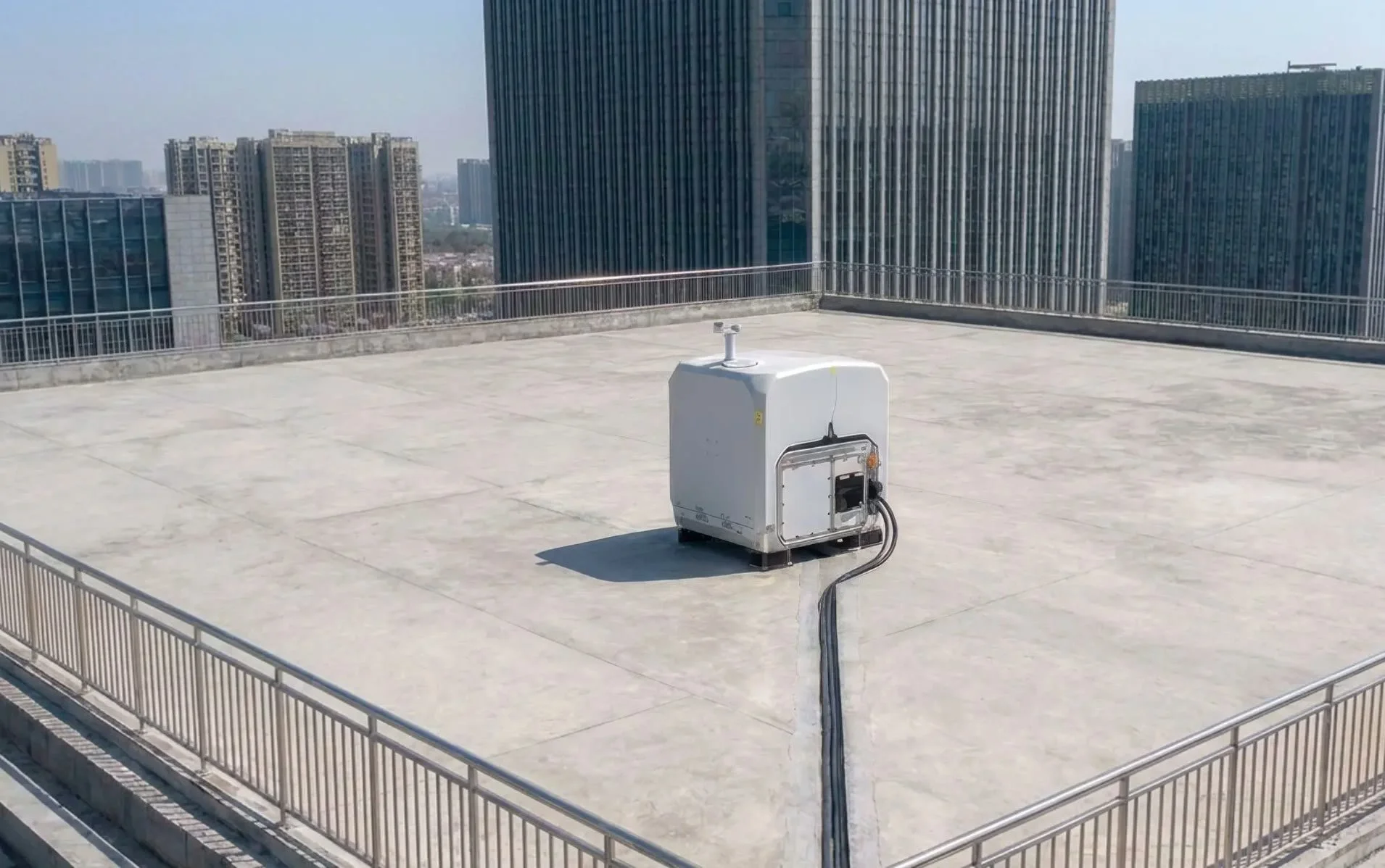 DJI Dock 4 and O4 Ground Station on a rooftop beside city high-rises