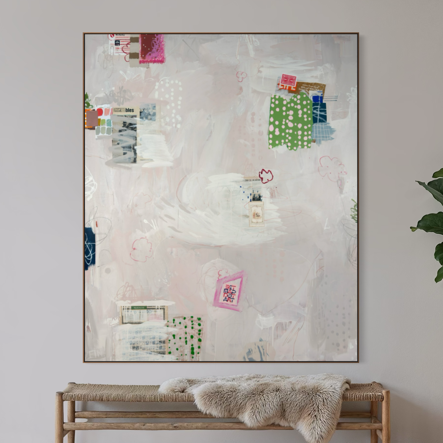 A minimalistic interior scene featuring a light wooden bench with a plush beige fur throw draped over it, placed against a white wall. A large abstract mixed media artwork with colorful patches, drawings, and collage elements hangs above the bench. T