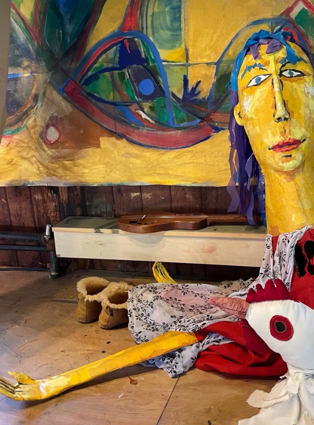 A life-size yellow puppet in front of a painting by Eva Zasloff at the Barn at Schwamb Mill, during A Very Special House, May 2026.