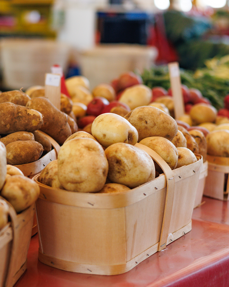 Pommes de terre dans un panier en bois à un marché