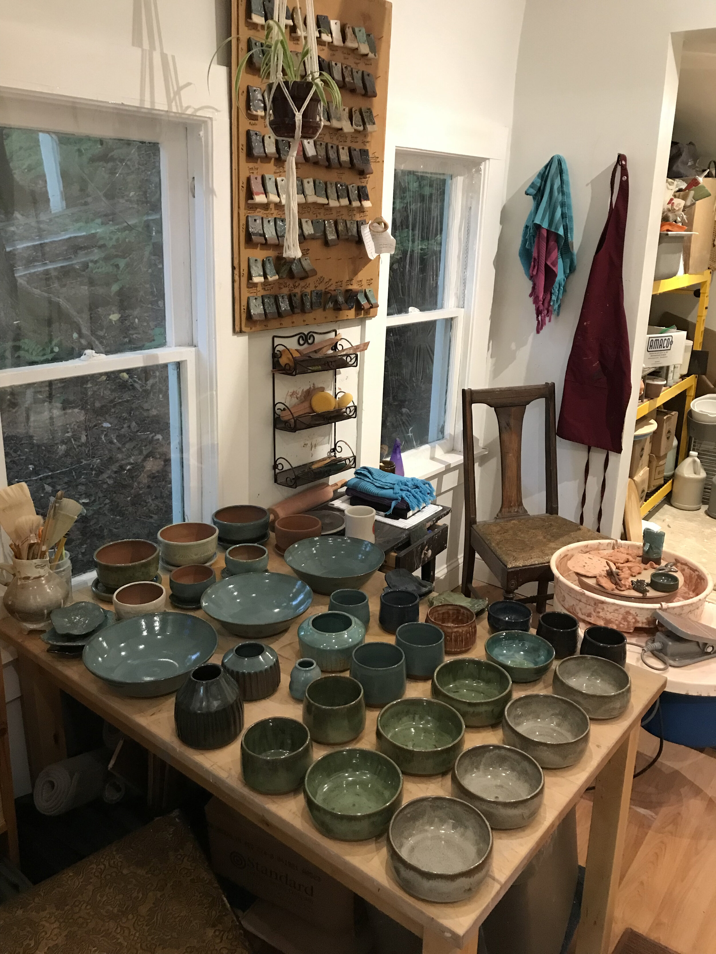 Table full of warm pots after unloading a glaze firing.