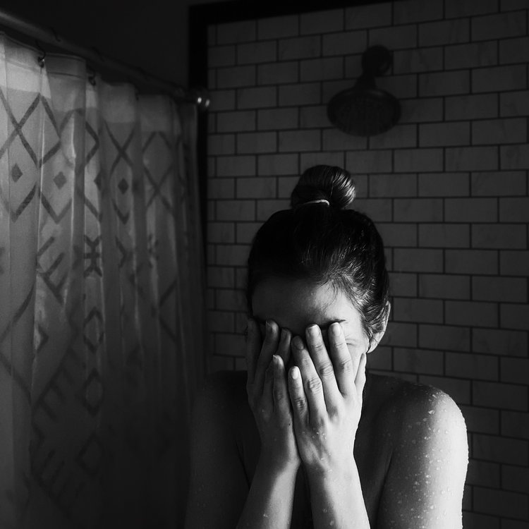 Girl in bathroom crying over stress of divorce