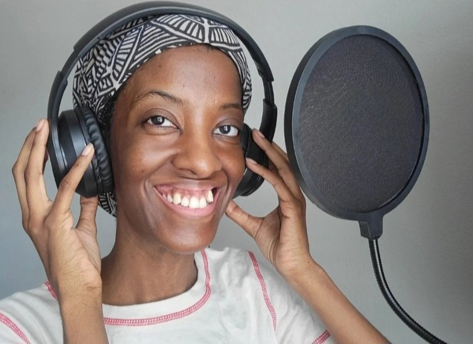 Hayley Armstrong - African American female voice actor smiling and holding headphones