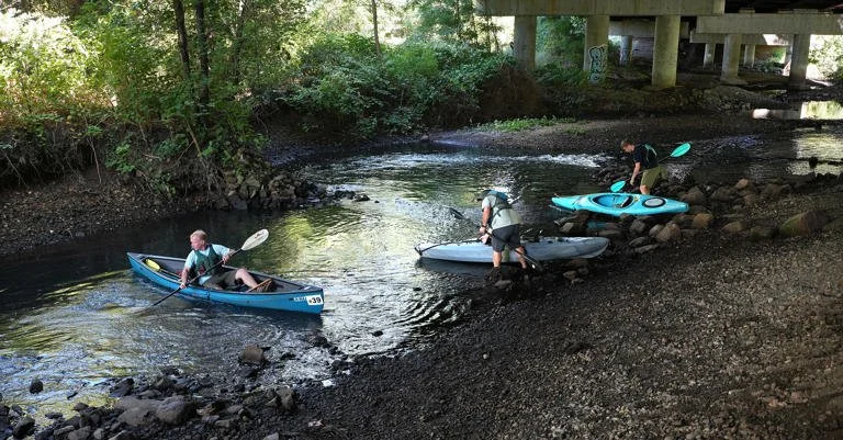 Three paddlers entering the Blackstone/Kittacuck in kayaks