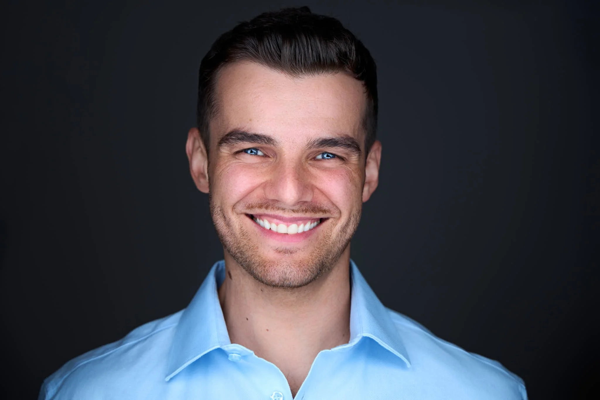 Professional headshot of a banker wearing a light blue dress shirt
