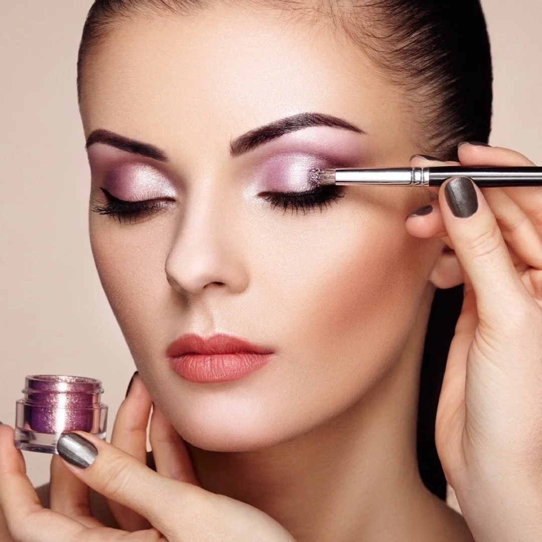 Woman applying shimmery pink eyeshadow with brush