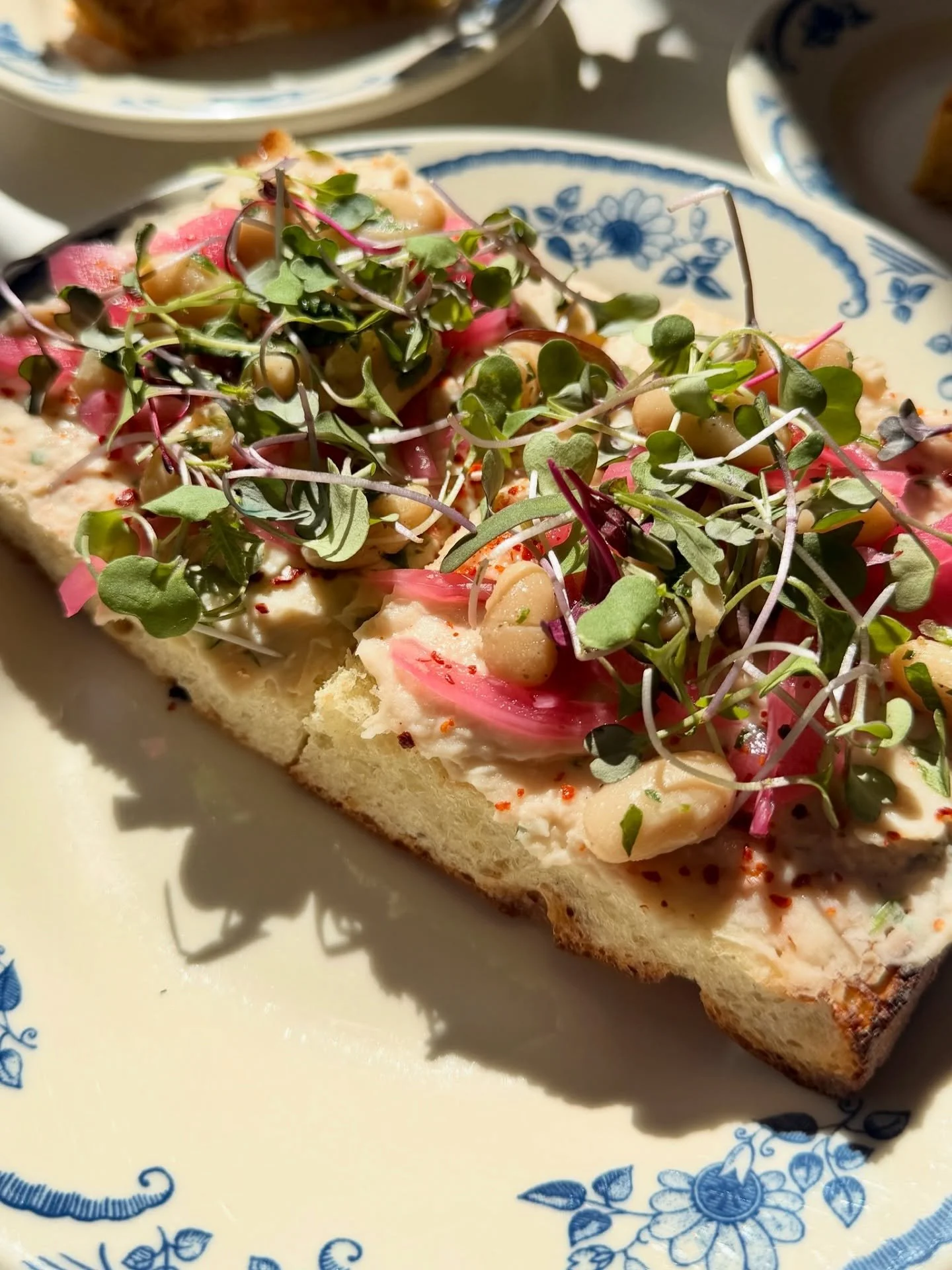 White Bean Toast is our fresh new take on a classic brunch item. Think of it as the tasty, savory cousin of Avocado Toast. 

White bean mash, roasted garlic, pickled red onion, Aleppo pepper, flaky sea salt, and organic micro greens on house-made foc