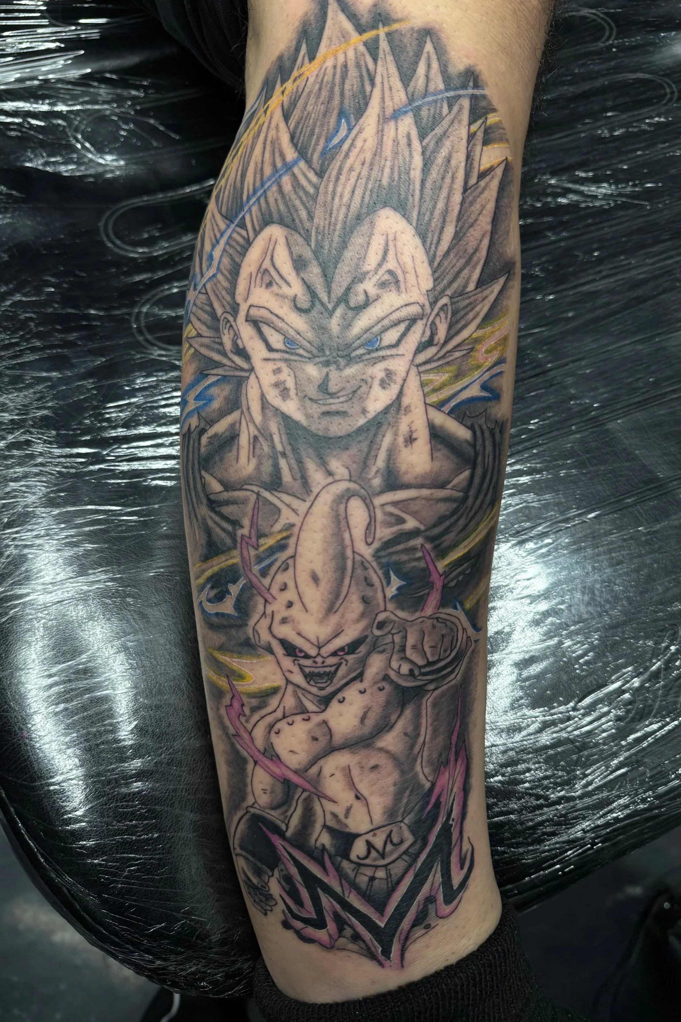 Tattoo of Goku and Kid Buu from Dragon Ball Z on a person's arm.