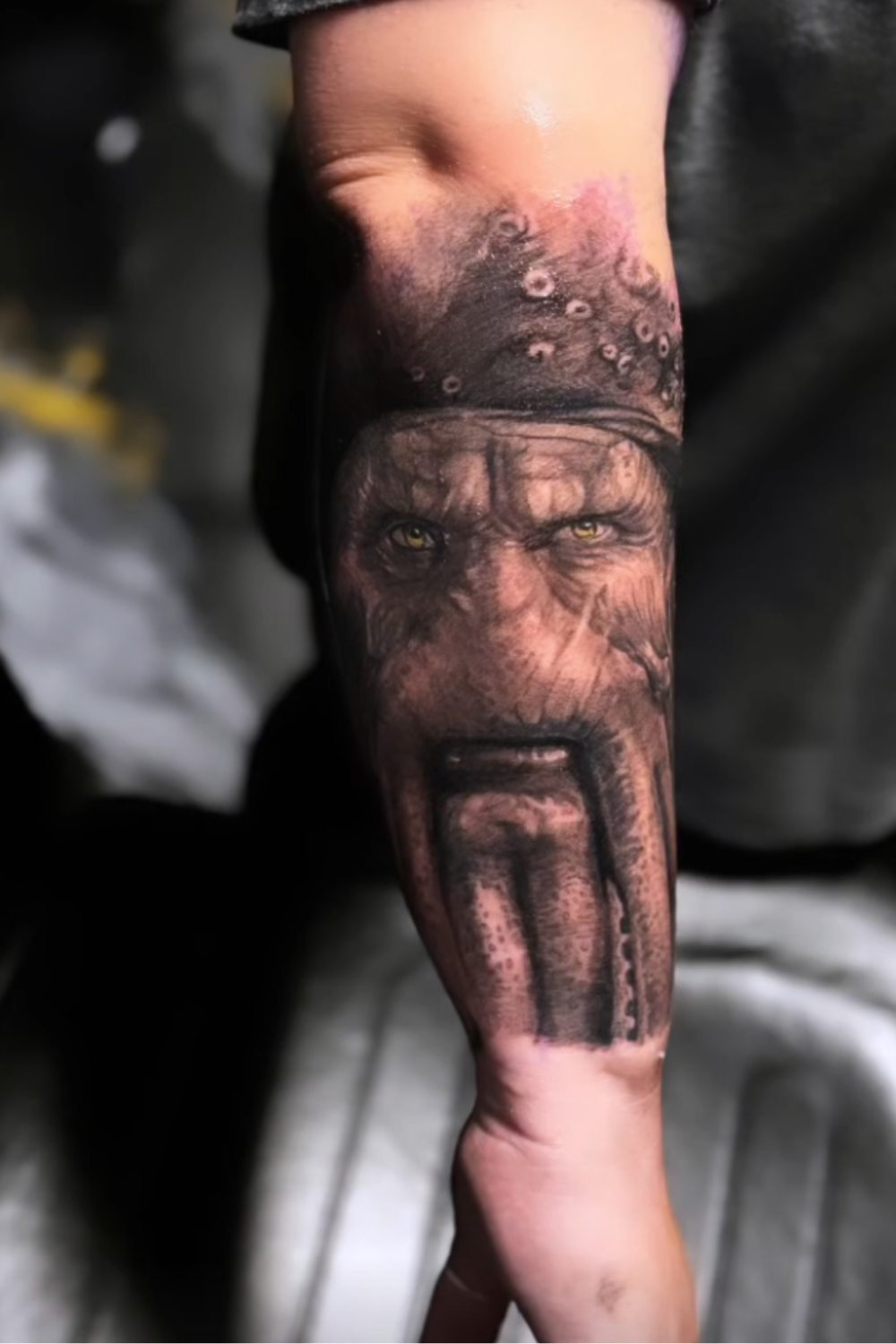 A detailed tattoo of a wolf's face on a person's forearm.