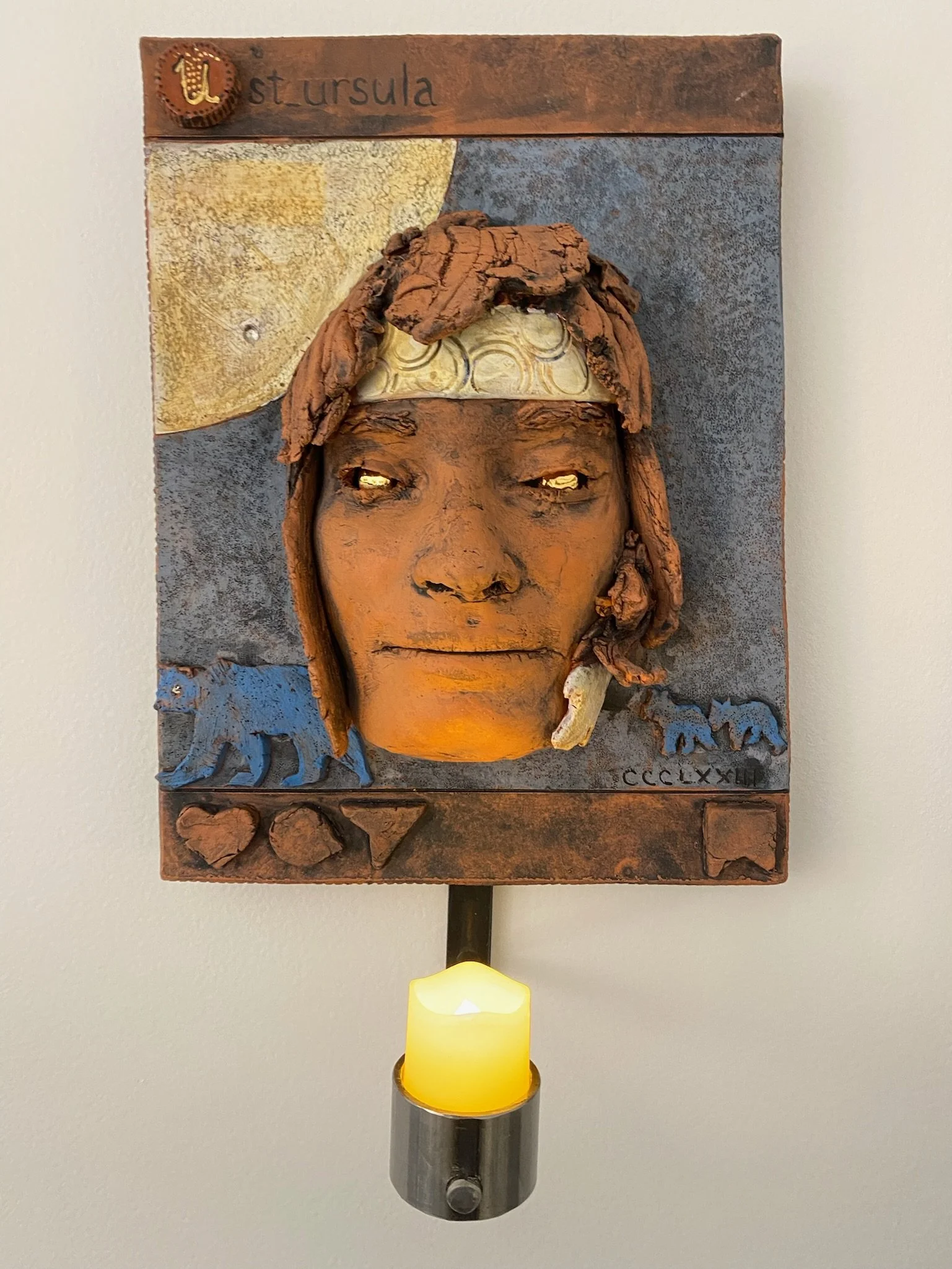 St. Ursula: 
Patron Saint of Teachers and Archers (Cornish 363-383) She started the Ursuline order of teaching nuns. Ursa means bear and I included a large blue bear and small blue bears, the big and little dippers. The moon references sky and passag